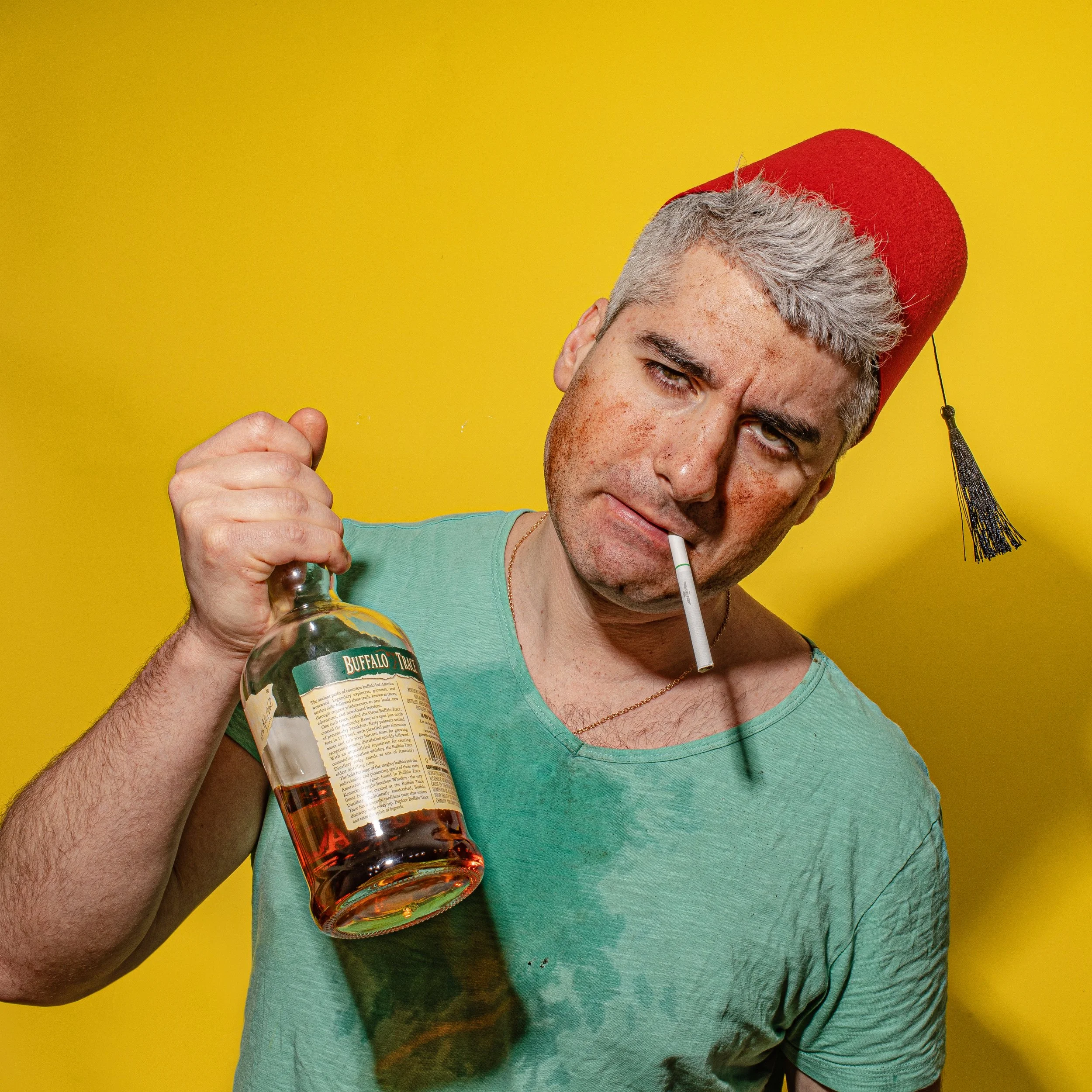 Dr. Honeybrew, Turkish coffee fortune teller in New York City's East Village, in a fez and holding a bottle of Buffalo Trace whiskey