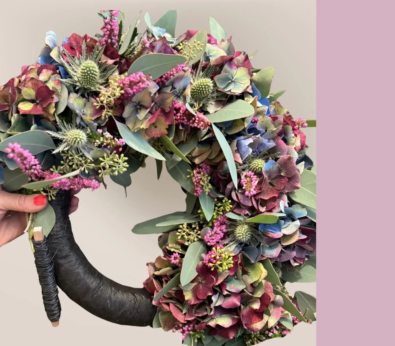 Grün, rosa, blauer Kranz aus herbstlichen Blumen