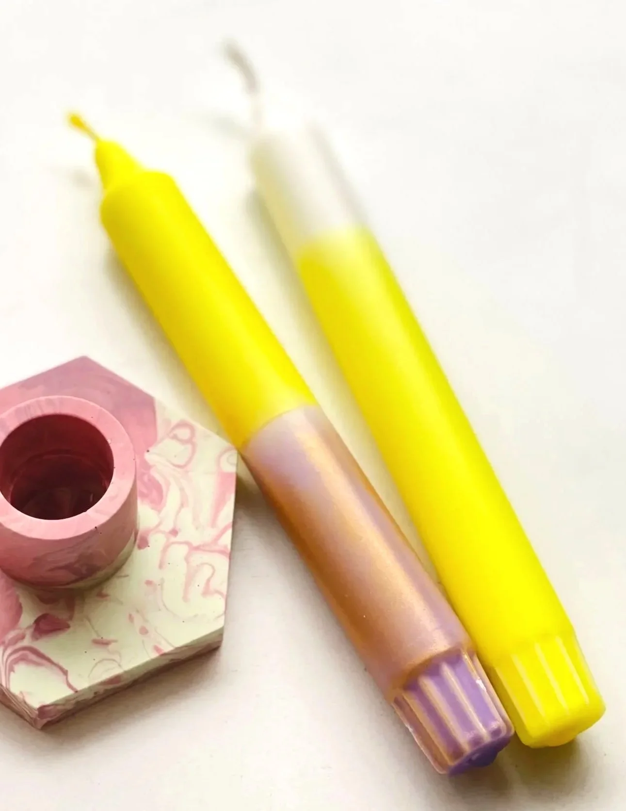 Zwei Kerzen in gelb und rosa gold