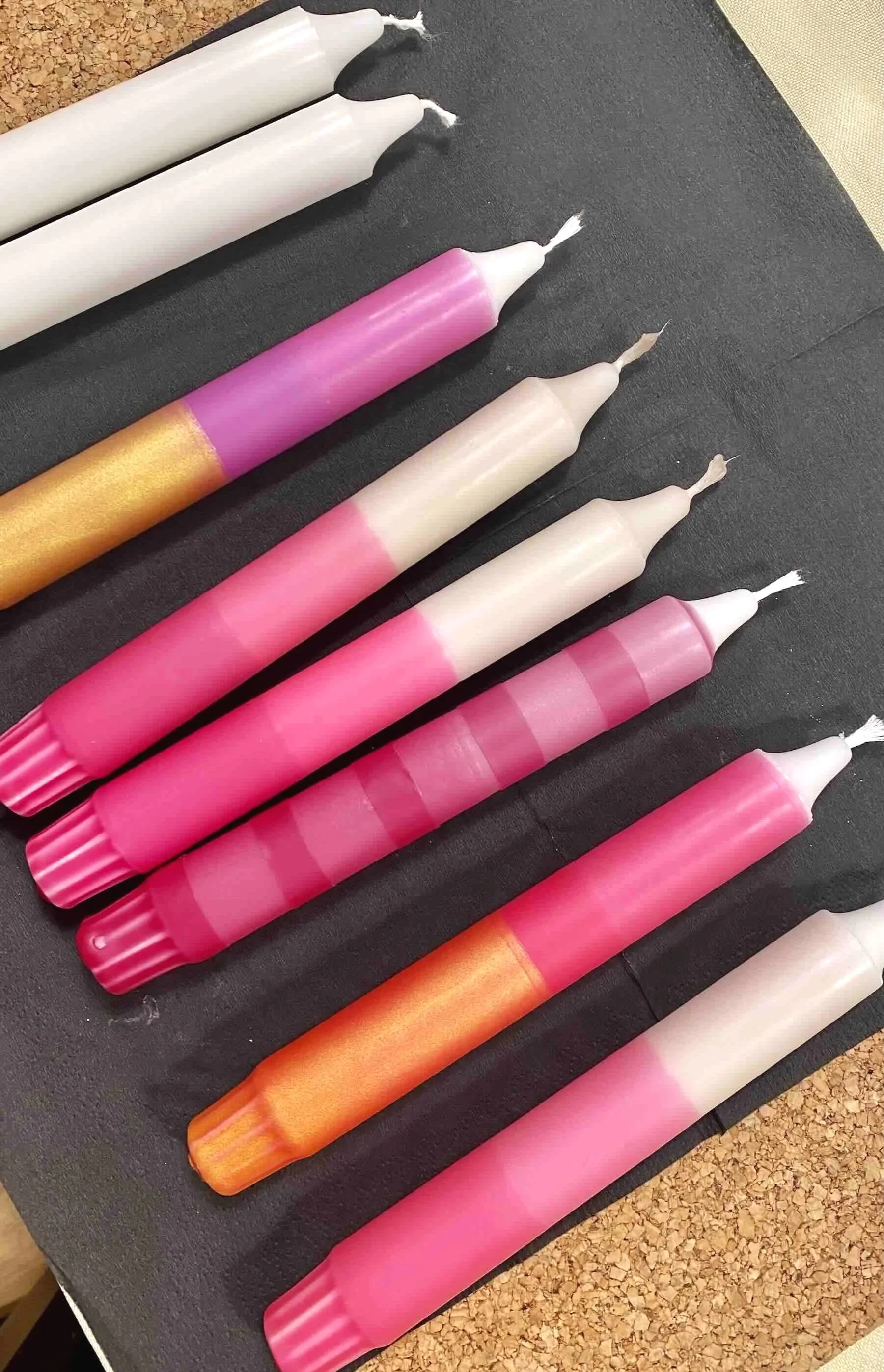 Sechs bunte Kerzen in Rosa, Rot und Gold