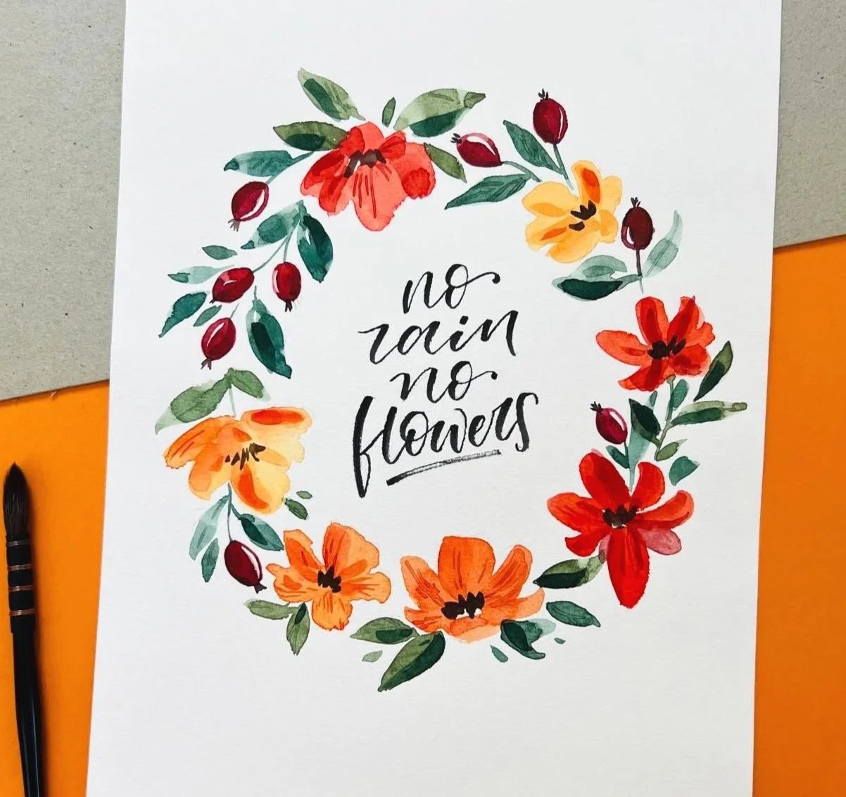 Handgemaltes Poster mit dem Zitat "no rain no flowers" umgeben von bunten Wasserfarben Blumen und Blättern in Gelb,, Orange, Rot und Grünund Pinsel