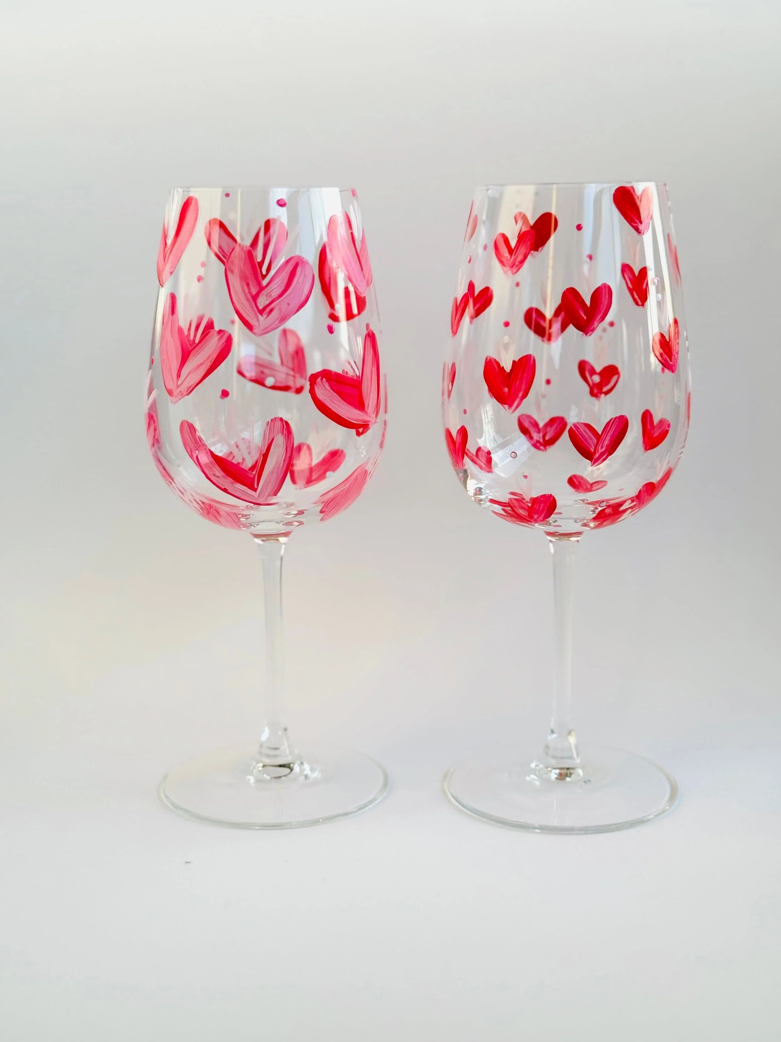 Zwei Weingläser mit roten Herzen als Dekoration.