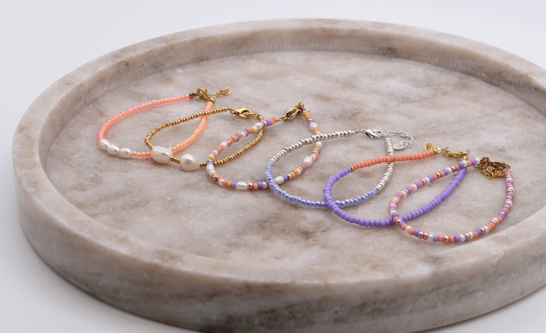 Sechs Armbänder aus bunten Glasperlen und  Süßwasserperlen mit goldenen und silbernen Verschlüssen