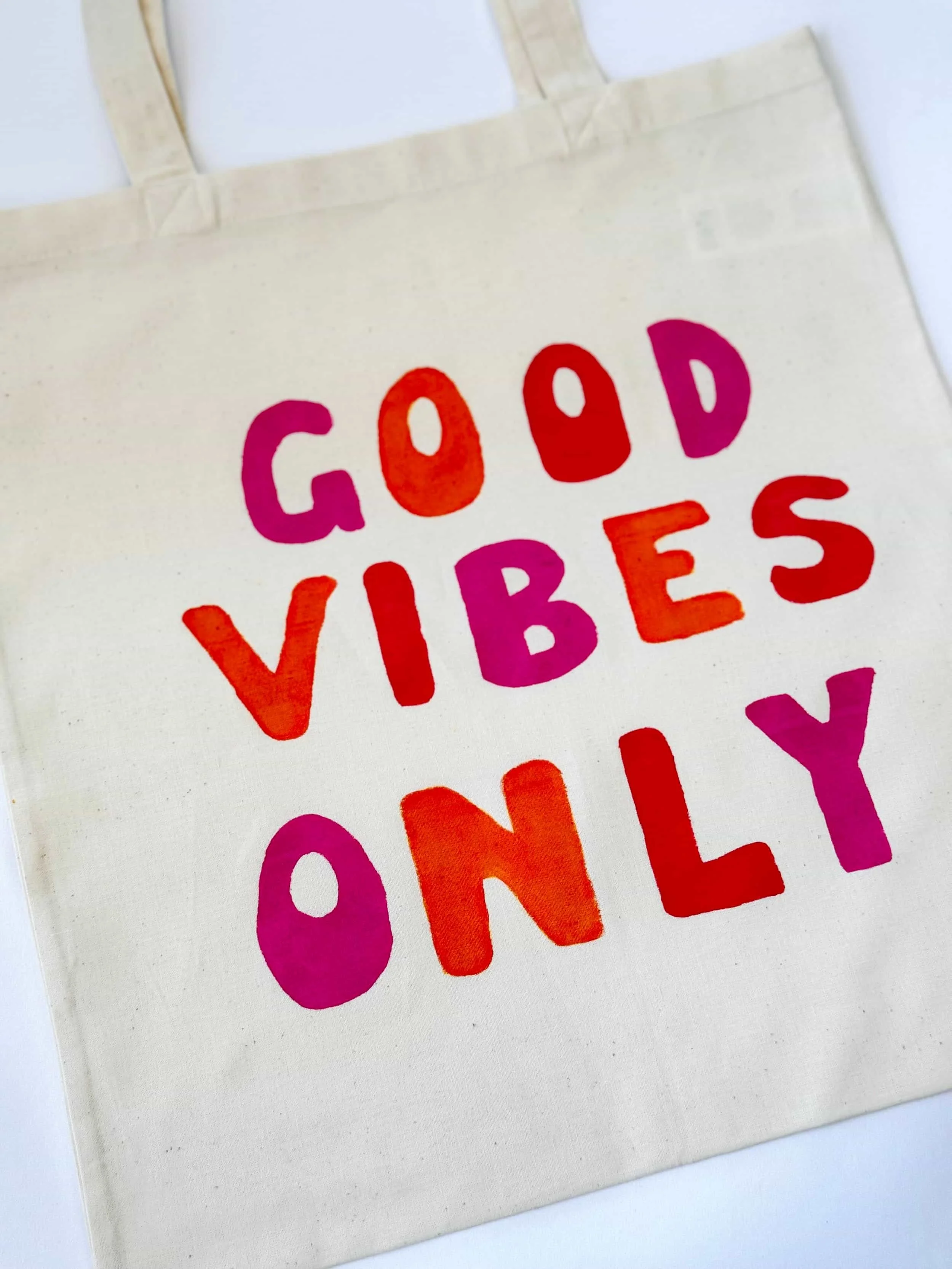 Bemalter Jutebeutel mit der Aufschrift "Good vibes only" in rot, orange und lila