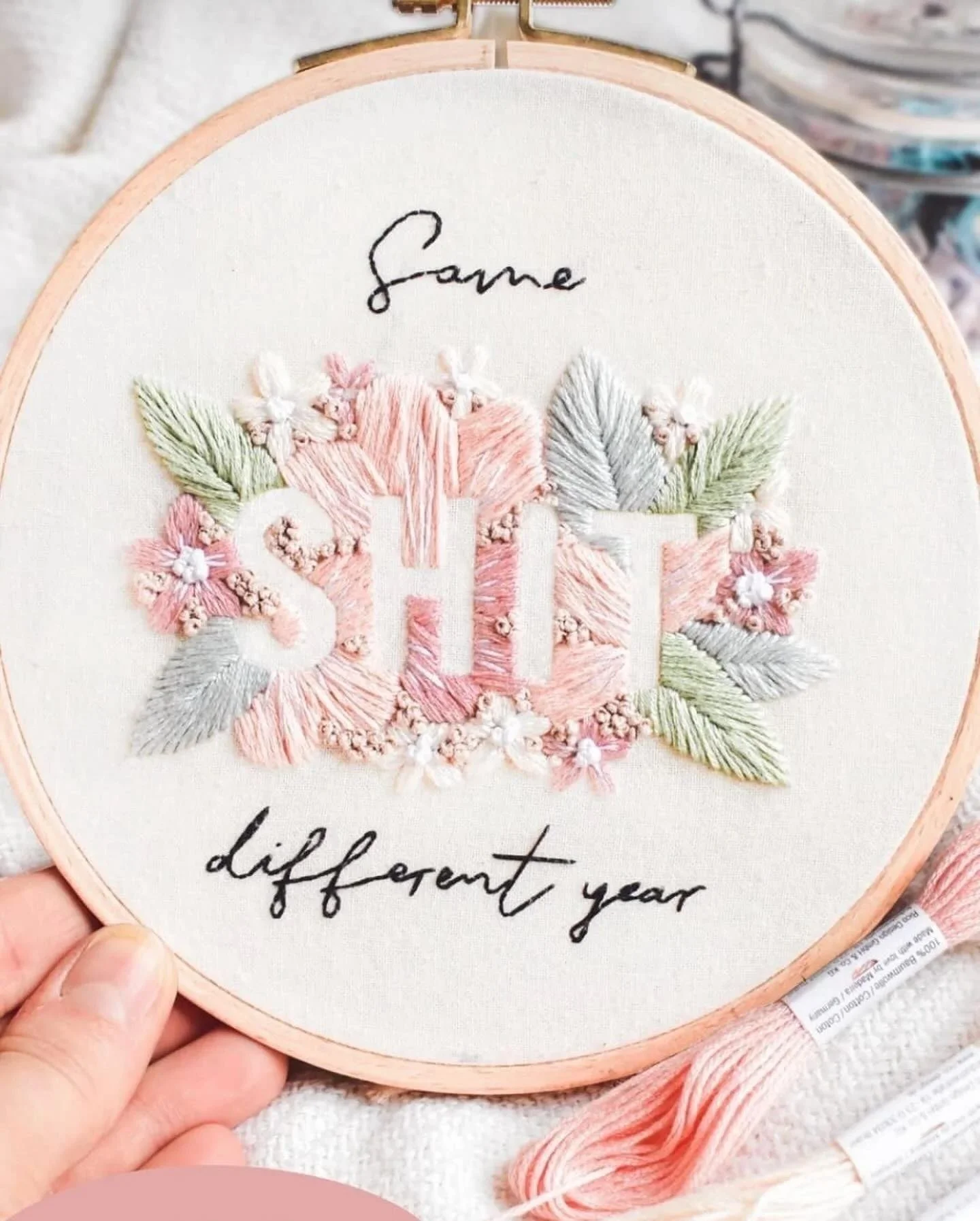 Stickerei mit Blumenmotiven und Text  'Same SHIT different year'
