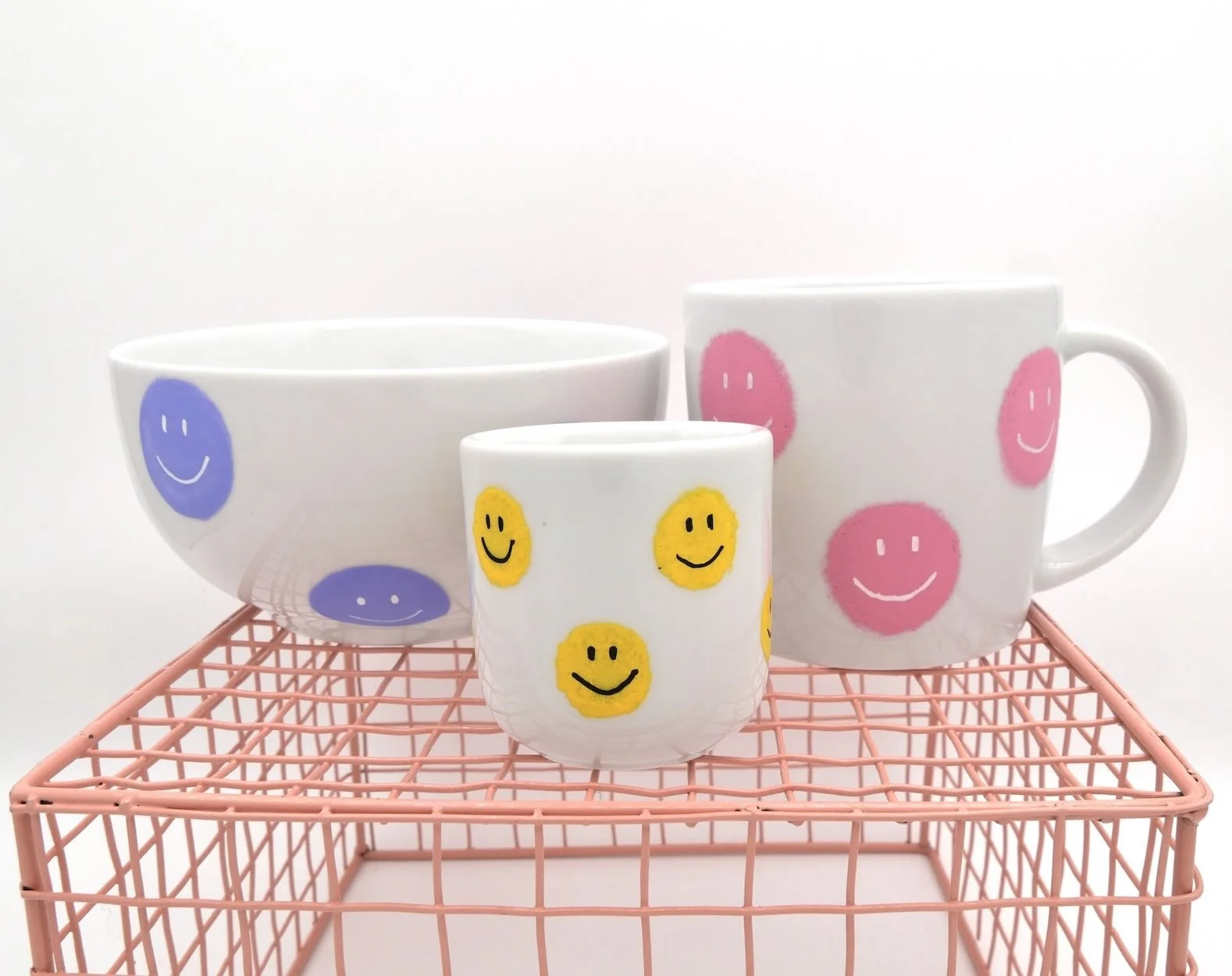 Weiße Müslischale bemalt mit Smileys in lila, Espresso Becher mit Smileys in gelb, Tasse mit Henkel mit Smileys in rosa