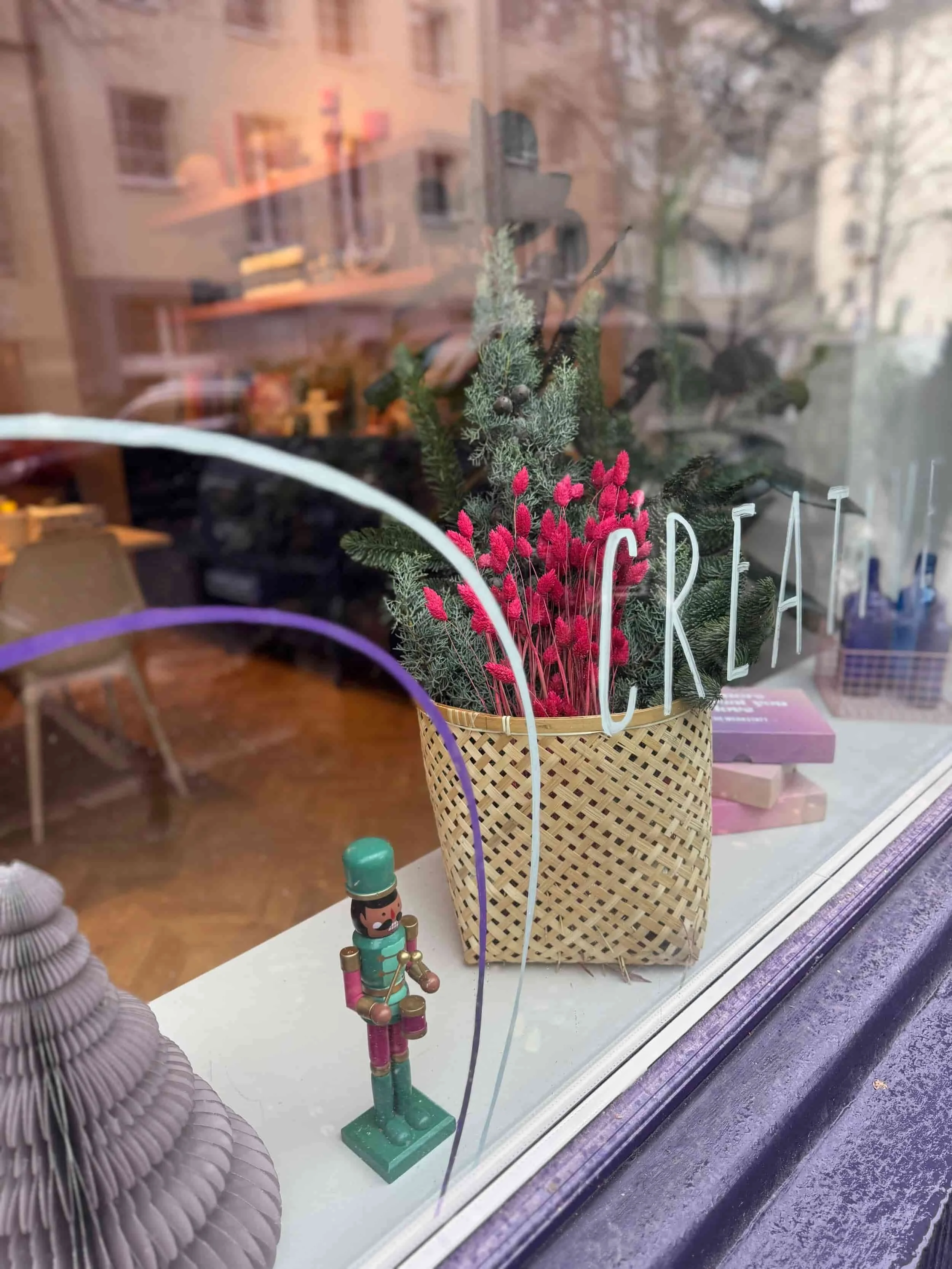 Schaufenster von The Werkstatt mit weihnachtlicher Dekoration und Fensterbemalung mit dem Wort Creative