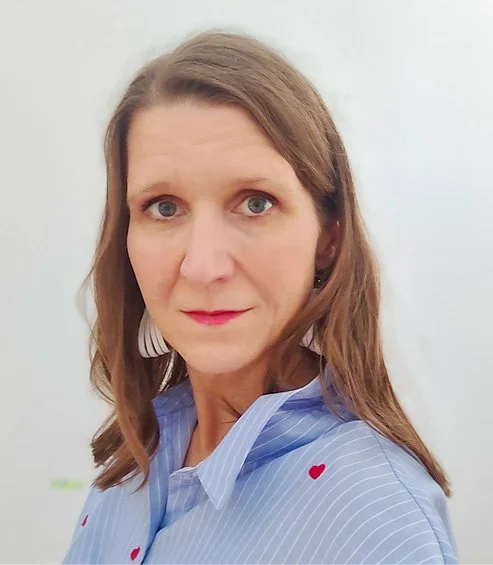 Frau mit langen Haaren, rotem Lippenstift und blauer Bluse mit Herzchen