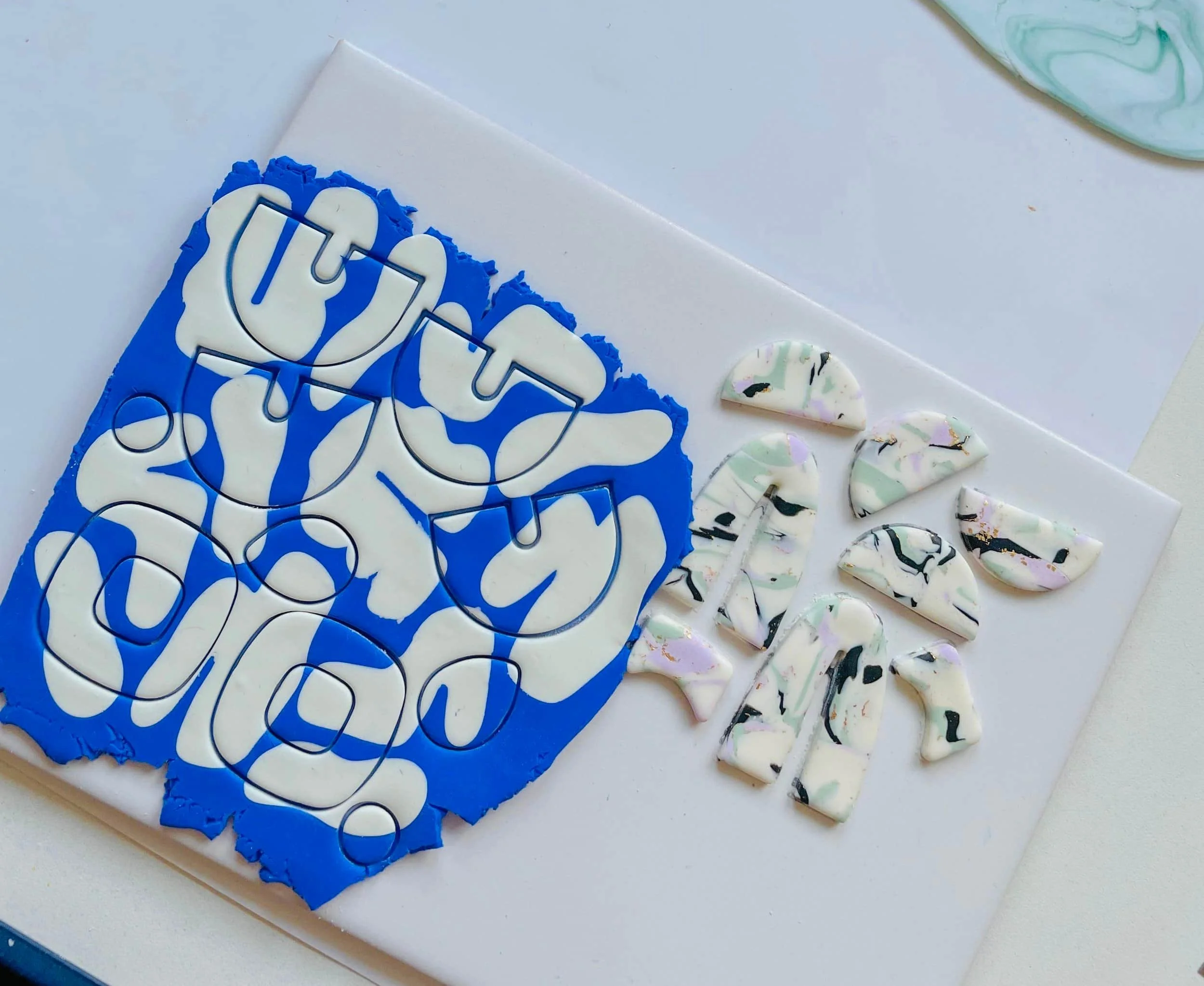 Polymer Clay masse in blau weiß ausgerollt und ausgestochen auf einem Tisch
