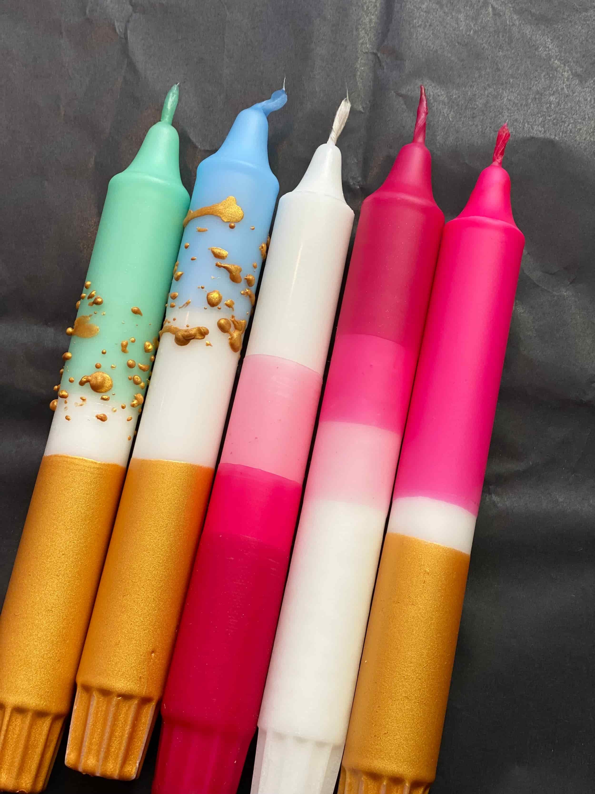 Fünf bunte Kerzen mit goldenen und farbigen Dekorationen