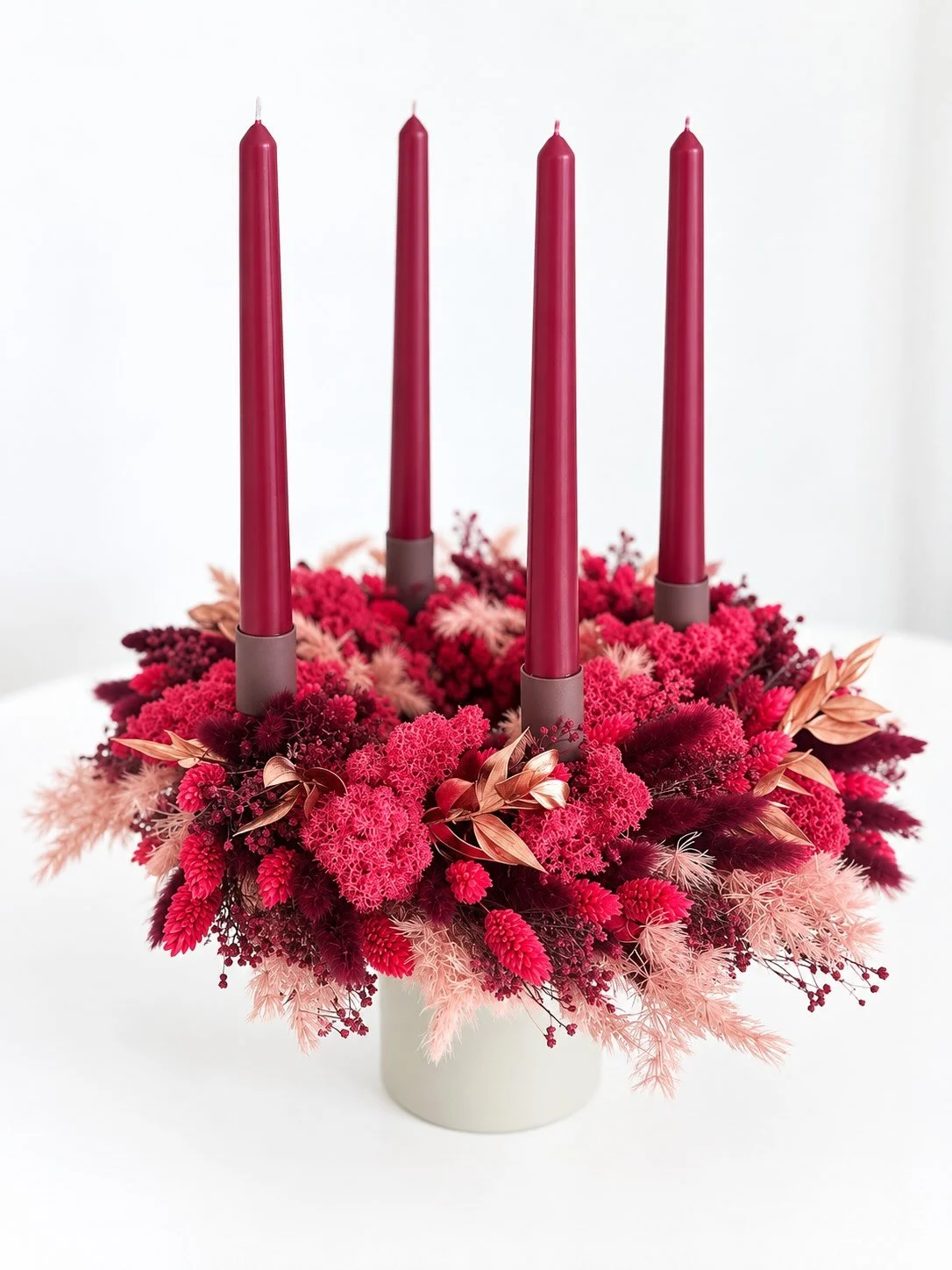 Trockenblumenkranz in rosa und dunkelrot mit vier dunkelroten Kerzen und Kerzenhalterungen