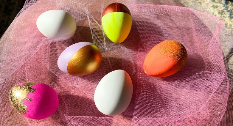 Bunte und weiße Eier auf dem rosa Tüllstoff