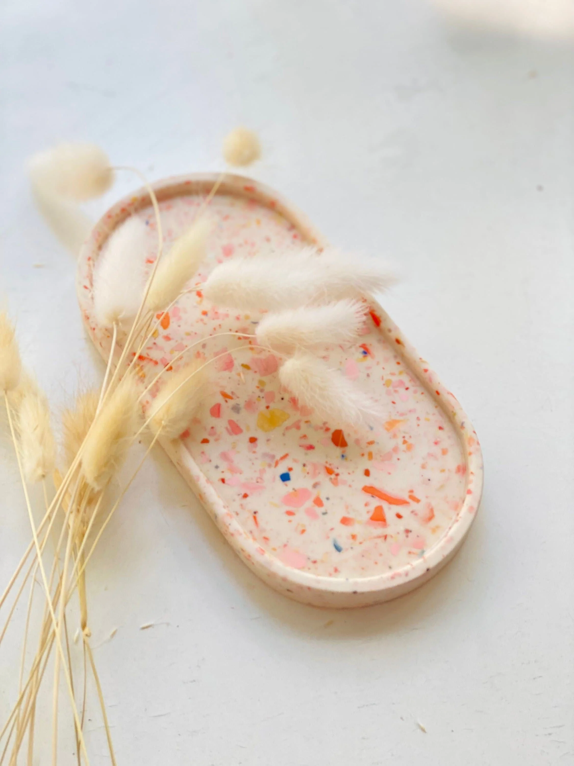 Terrazzo Schale in naturtönen mit bunten Terrazzosteinen, mit beigen und weißen Trockenblumen