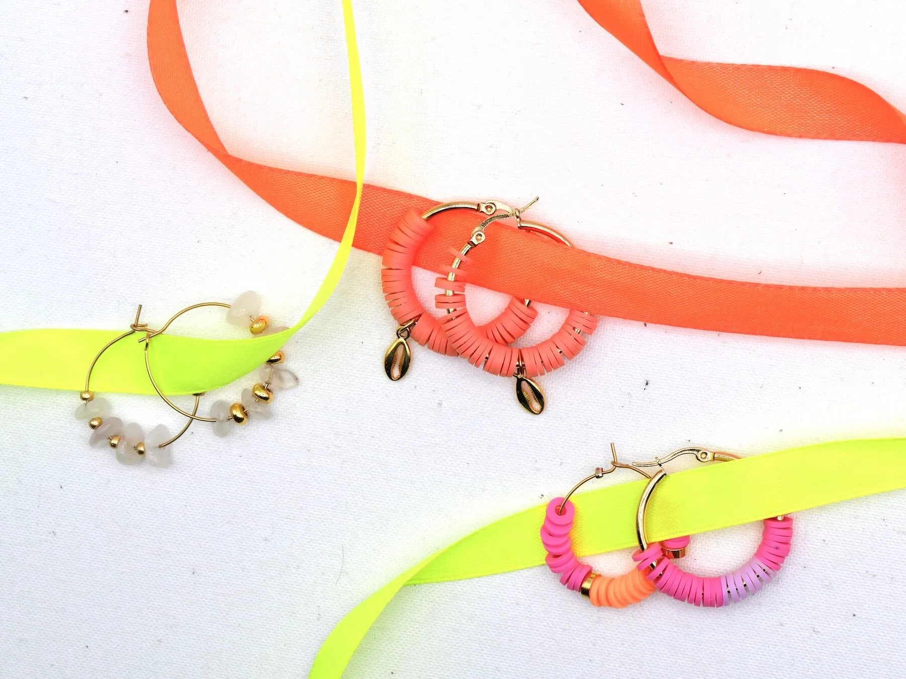 Drei Paar Creolen in orange mit goldenen Muschelanhänger, in rosa, orange, lila und mit rosa Natursteinen und goldenen runden Perlen geschmückt