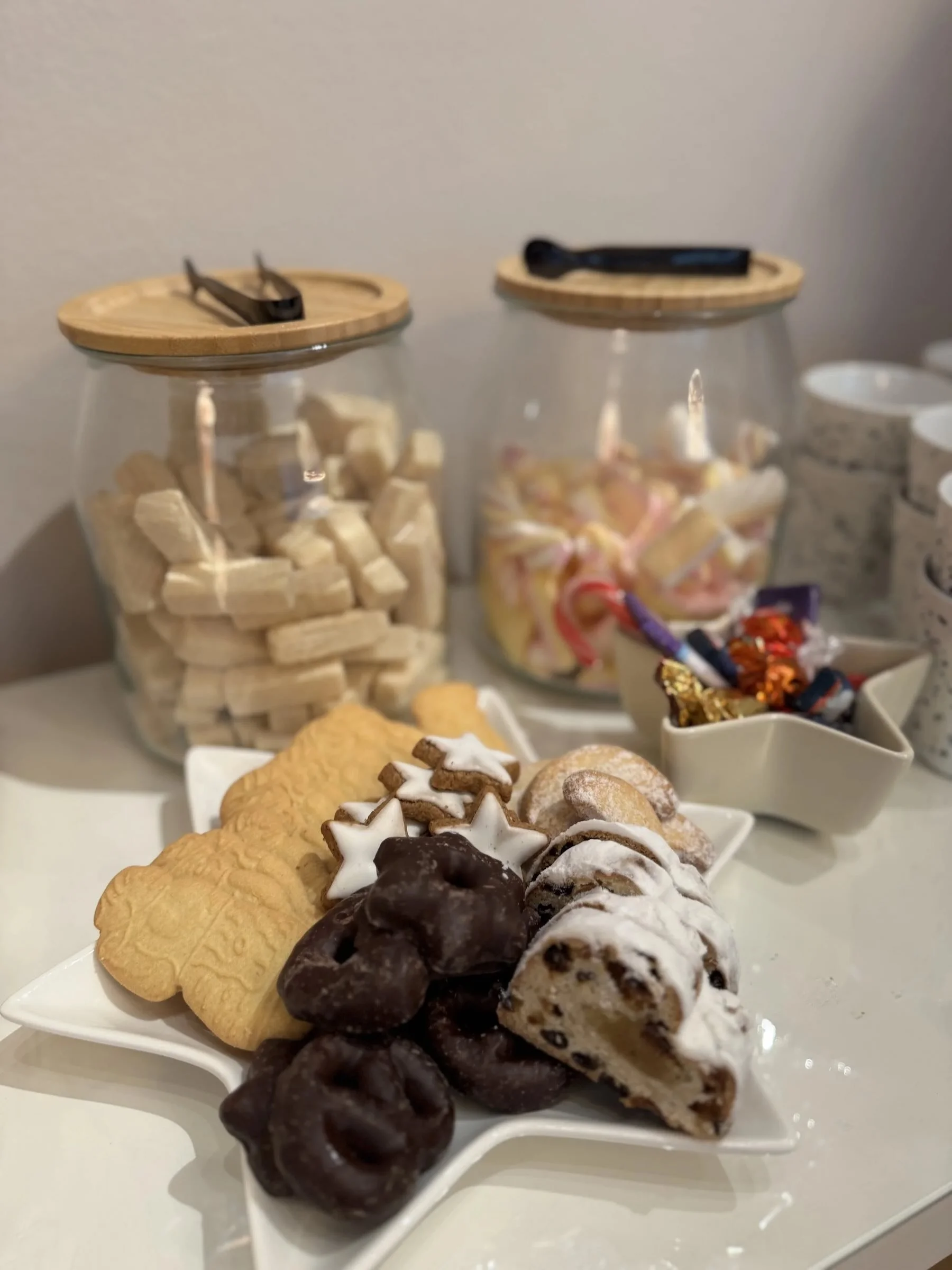 Teller voller Spekulatius, Schockolebkuchen, Stollen, im Hintergrund Candybar mit zwei großen Gläsern