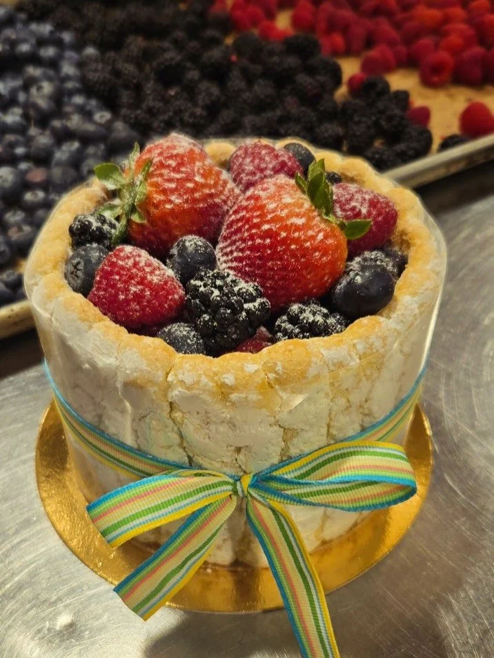 Fresh Fruit Charlottes are made for spring!  Delicate airy ladyfingers surround lemon mousse  and fresh berries 🫐🍓🍋
Available at both bakeries 4/1 - 4/4, 
or place a special order online for pickup on Saturday 4/4.  Special order link in bio and o