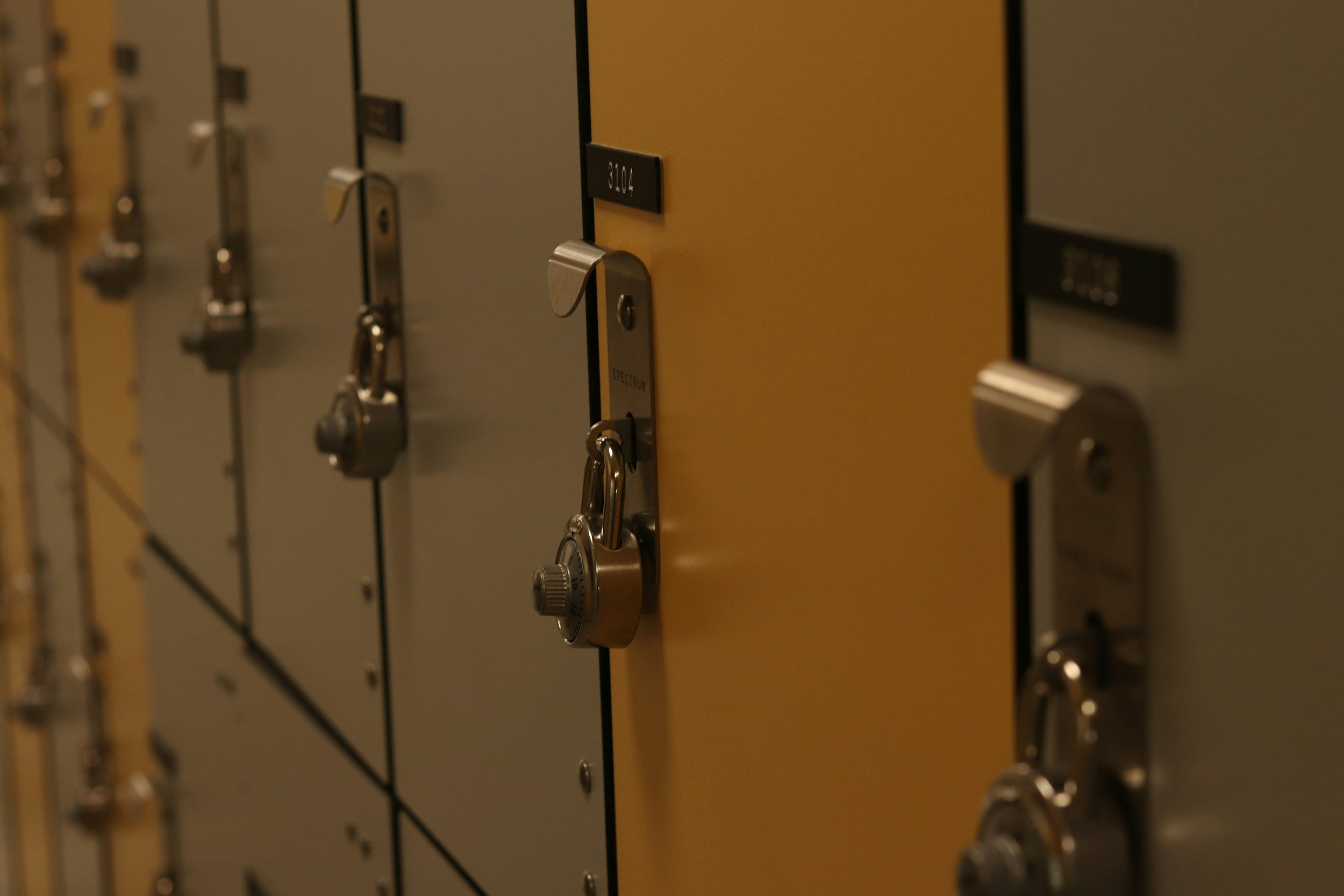 School lockers with combination locks, some yellow and some gray.