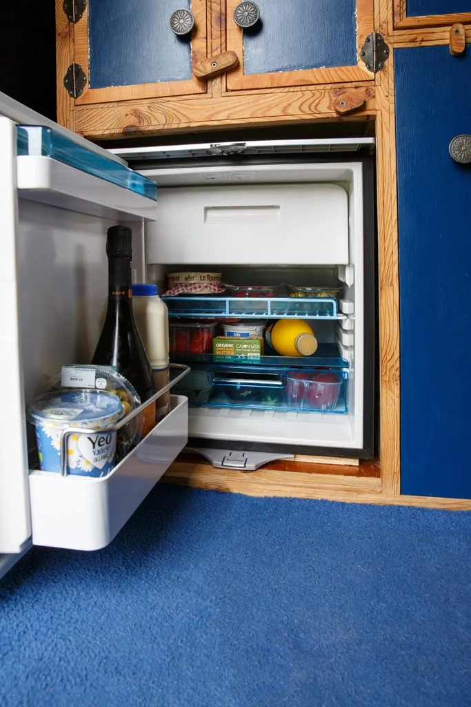 Built-in fridge freezer inside Azure’s handmade campervan kitchen, offering practical cold storage for fresh food and drinks on the road. A key feature of Azure’s thoughtfully designed campervan and motorhome hire from Bristol.