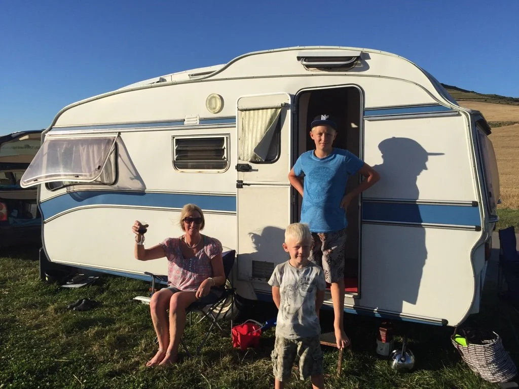 My mum with my two boys outside our caravan during family travels in France