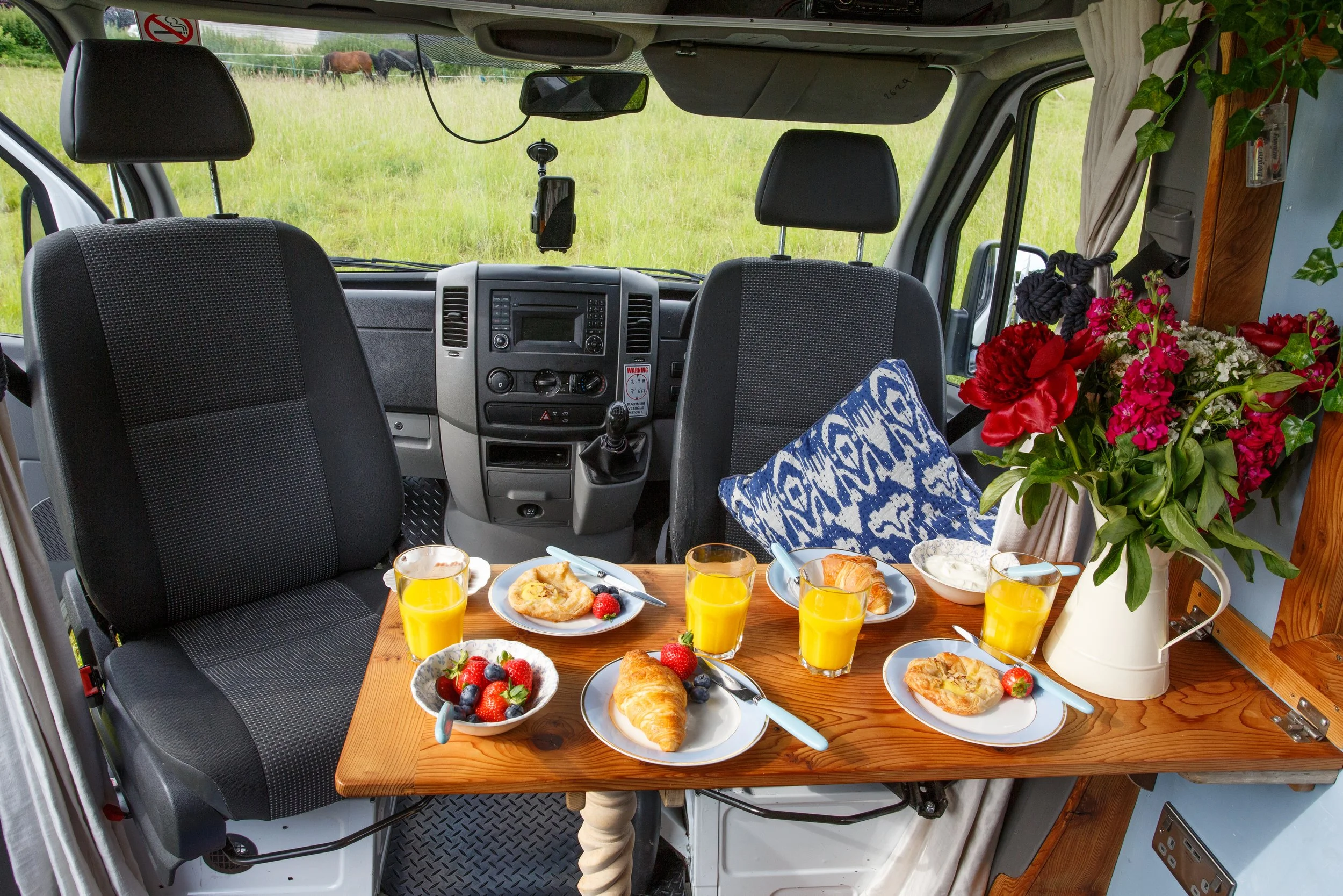 Breakfast set up inside Azure, showing the cosy dining area and handcrafted interior details, ideal for relaxed campervan motorhome hire from Bristol.