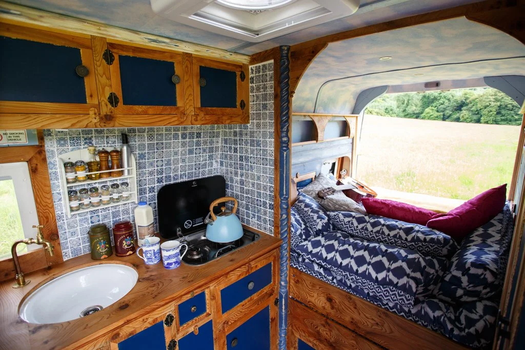 A view through Azure’s interior showing the handcrafted kitchen and cosy sleeping area, designed for relaxed campervan motorhome hire from Bristol with comfort, style and practicality in mind.
