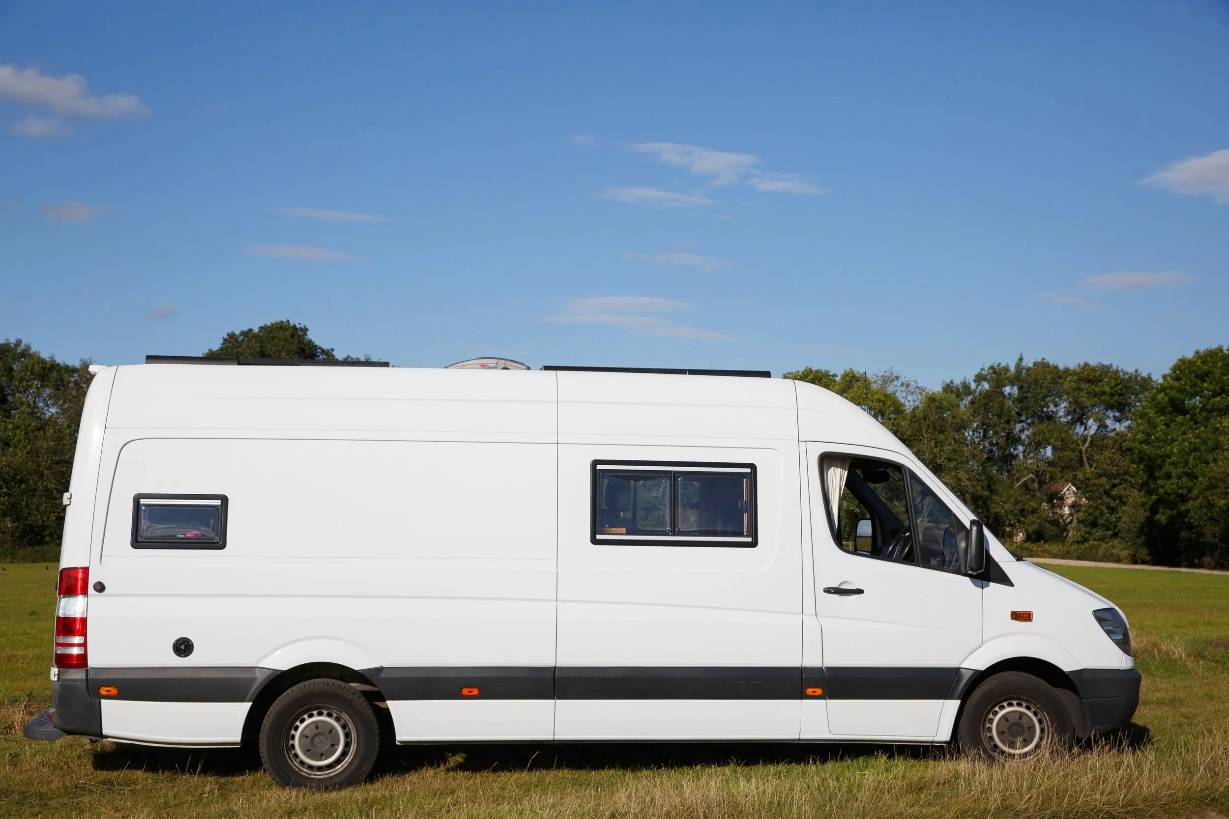 Azure campervan side profile, a spacious off-grid Mercedes Sprinter available for campervan and motorhome hire in Bristol. With a long-wheelbase design, extra windows for light and airflow, and a high roof for comfortable standing room, Azure is idea