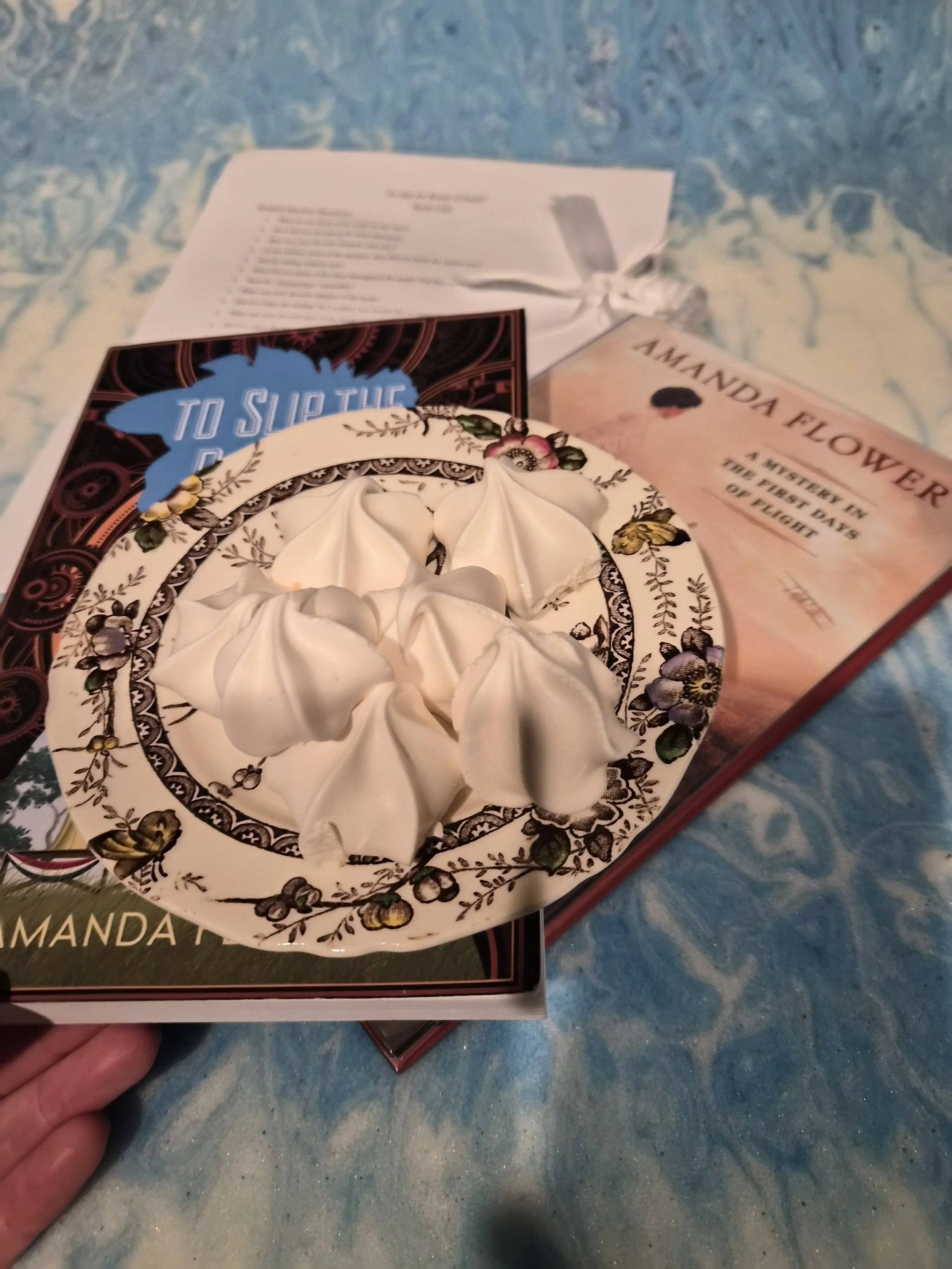 Vanilla meringues are next to the books.