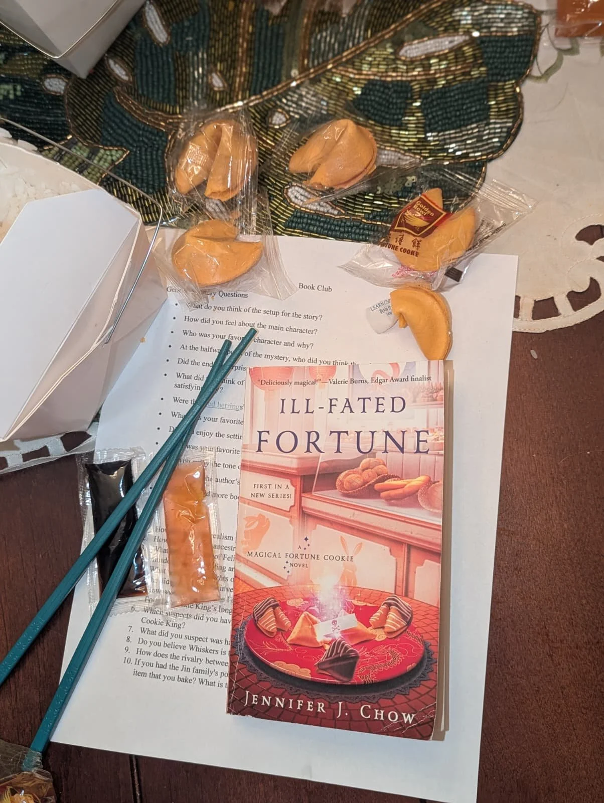 Chinese food an chopsticks next to the book Ill-Fated Fortune