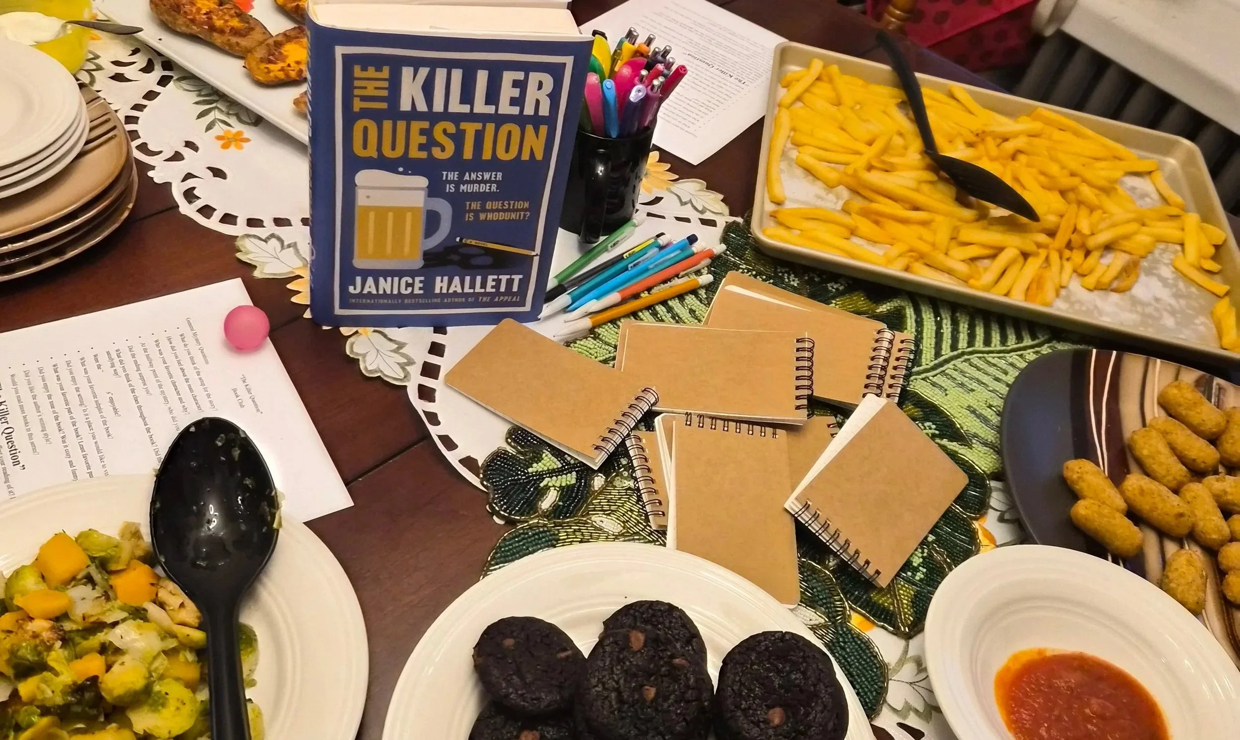 Bar food snacks with french fries prominent next to the book "The Killer Question".