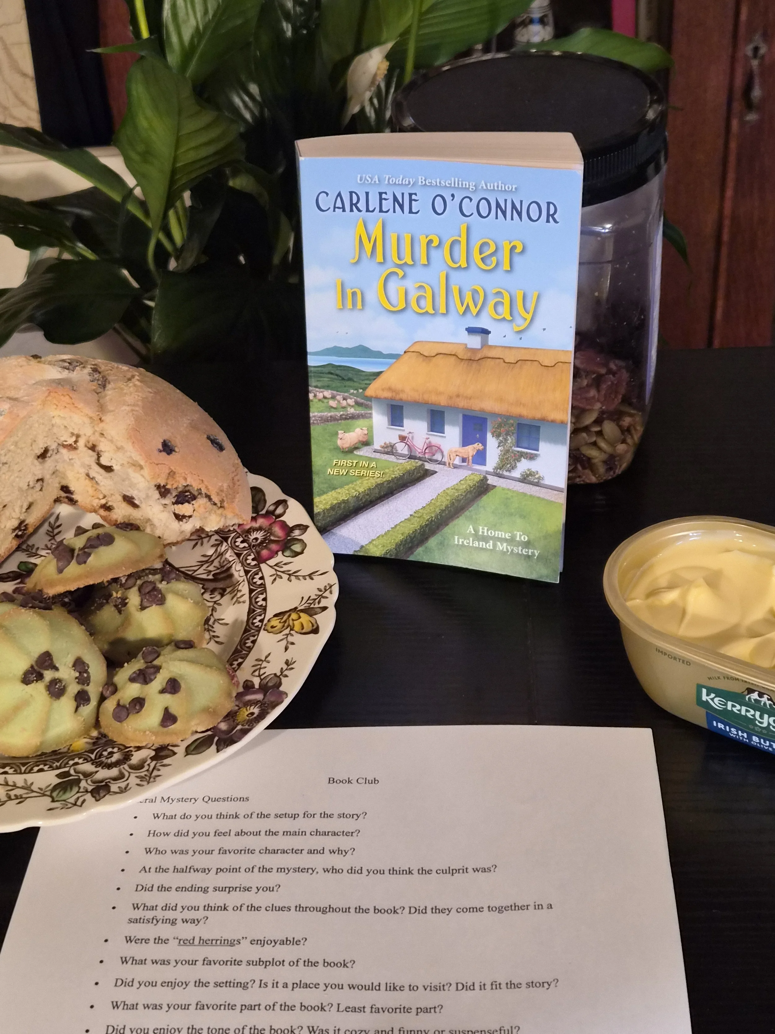 Irish soda bread and green cookies next to the book ""Murder in Galway.
