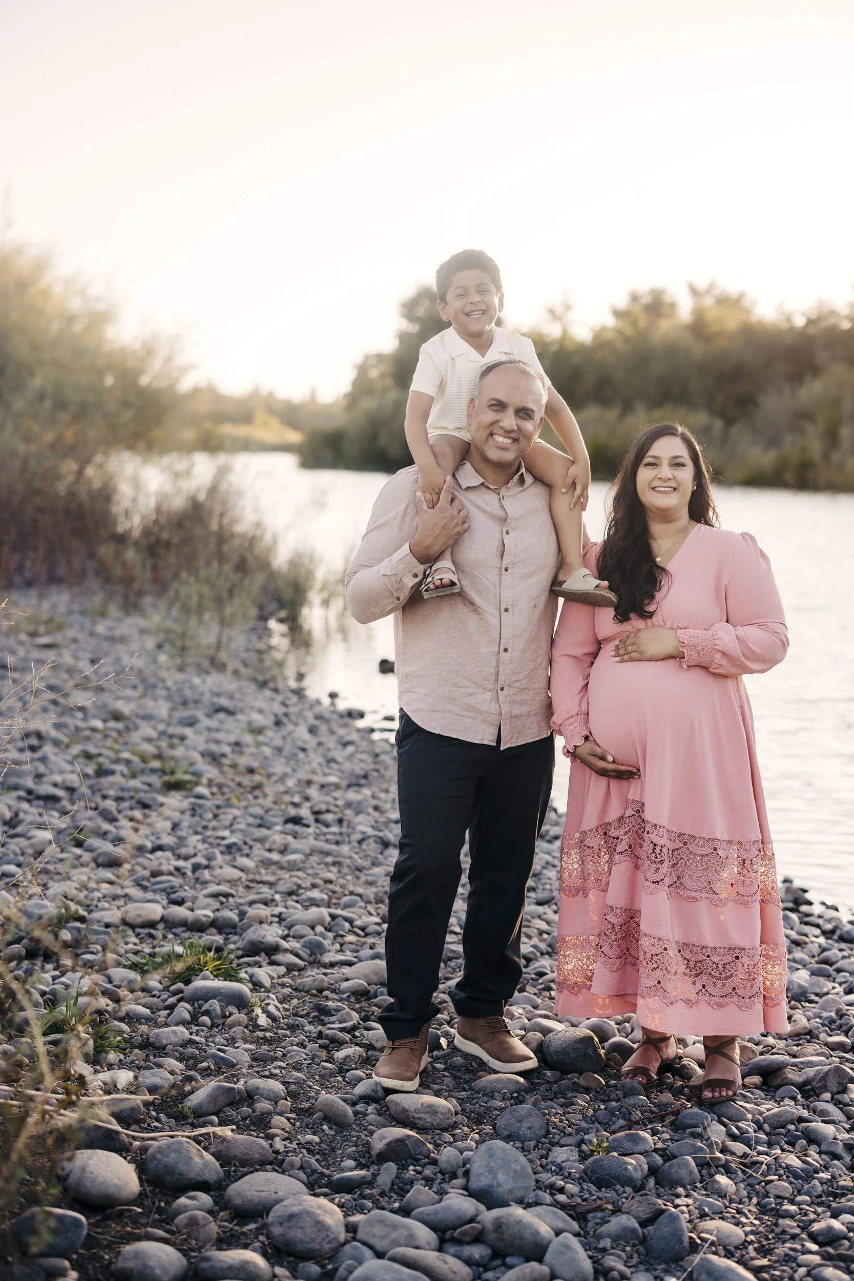 A family of three enjoys time by the river with Roseville Maternity Photographer Amy Wright.