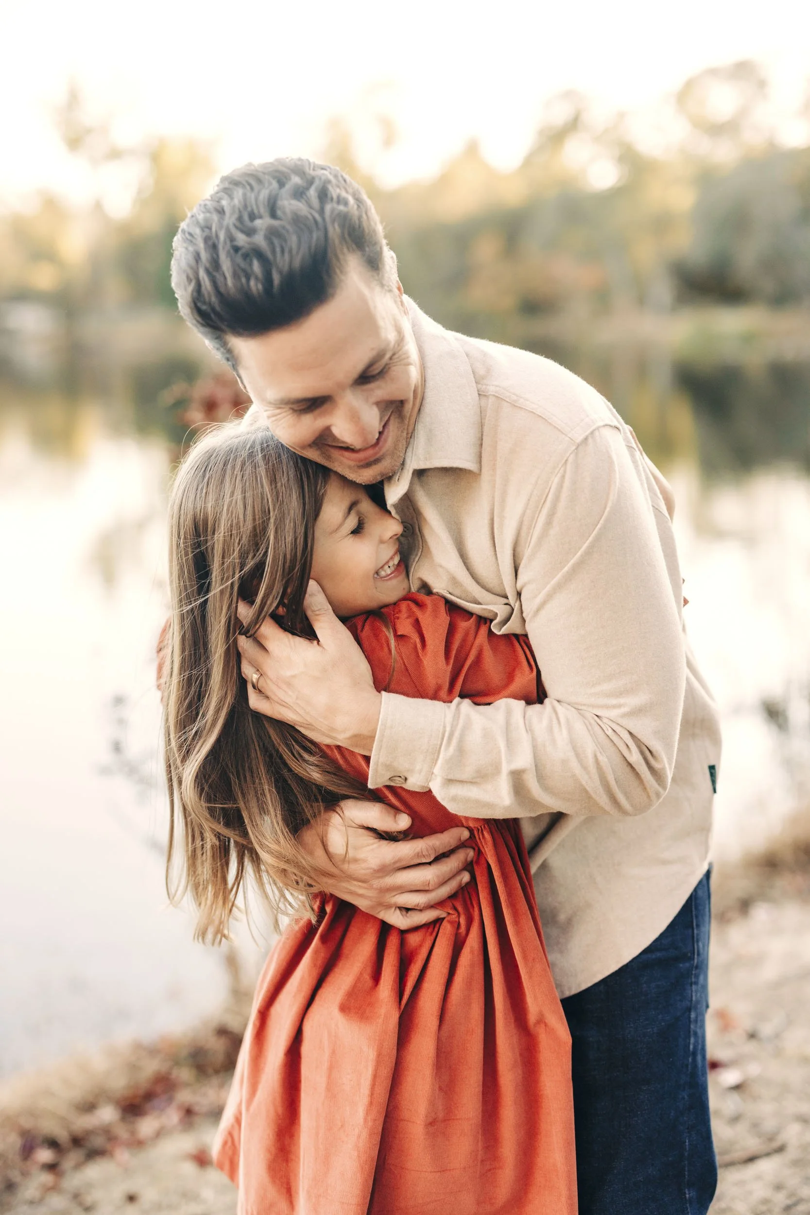 A father hugs his daughter during family pictures with Roseville photographer Amy Wright