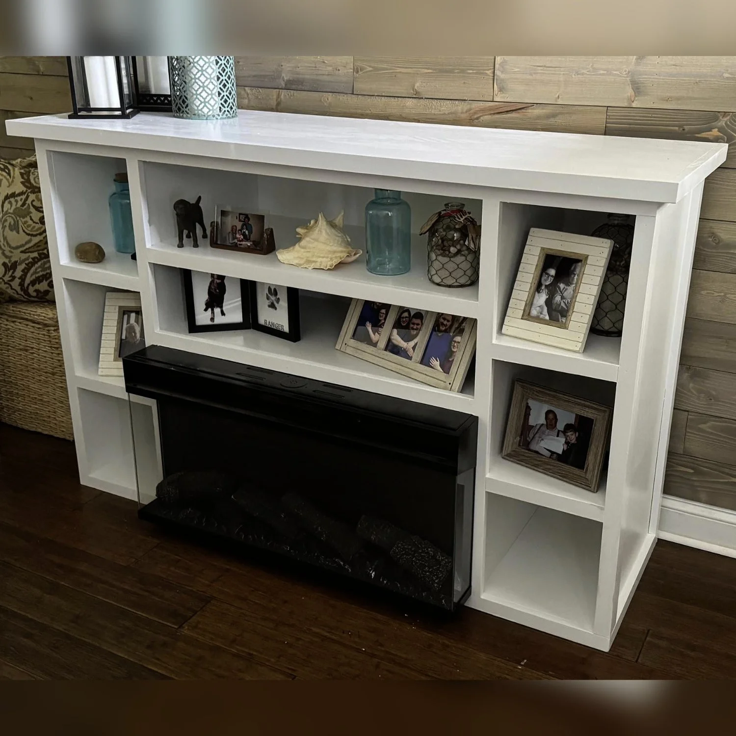This fireplace built-in stand houses a fireplace insert and  sits perfectly beneath a wall-mounted TV in a living room or wherever you need extra display storage.