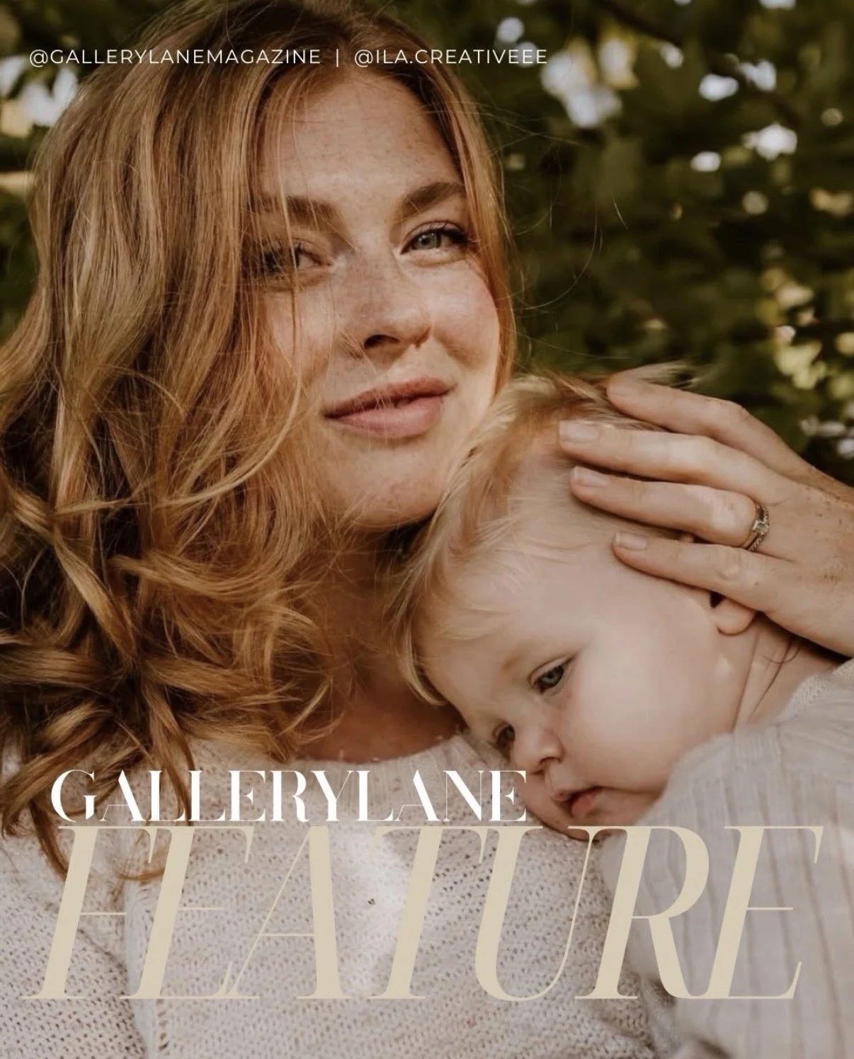 A woman with long, wavy red hair gently holds a young child with blonde hair close to her chest, both appearing calm and content. They are outdoors, with blurred greenery in the background.