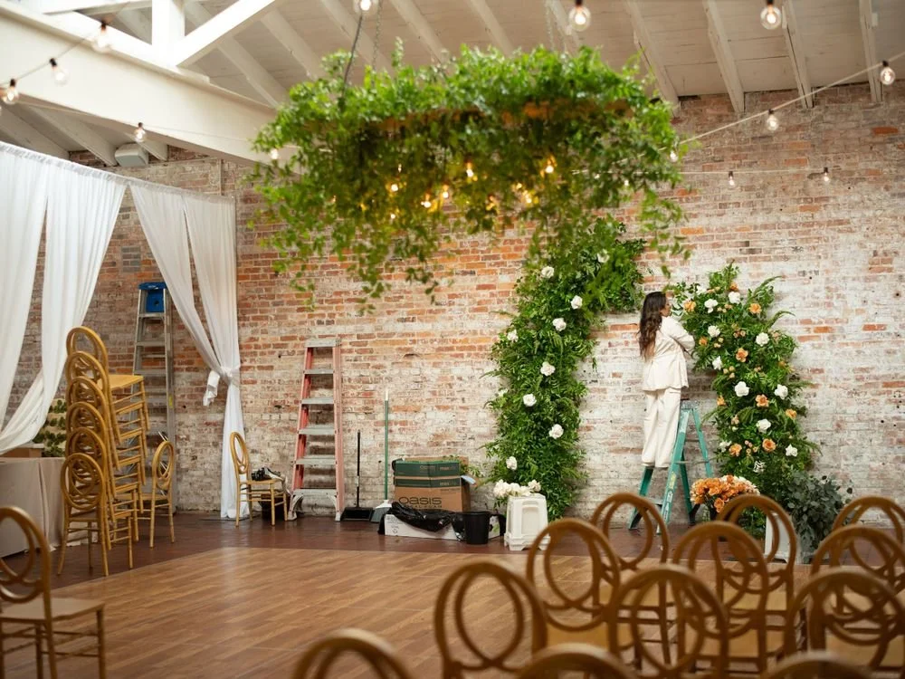 Florist setting up wedding flowers before guests arrive at the venue.