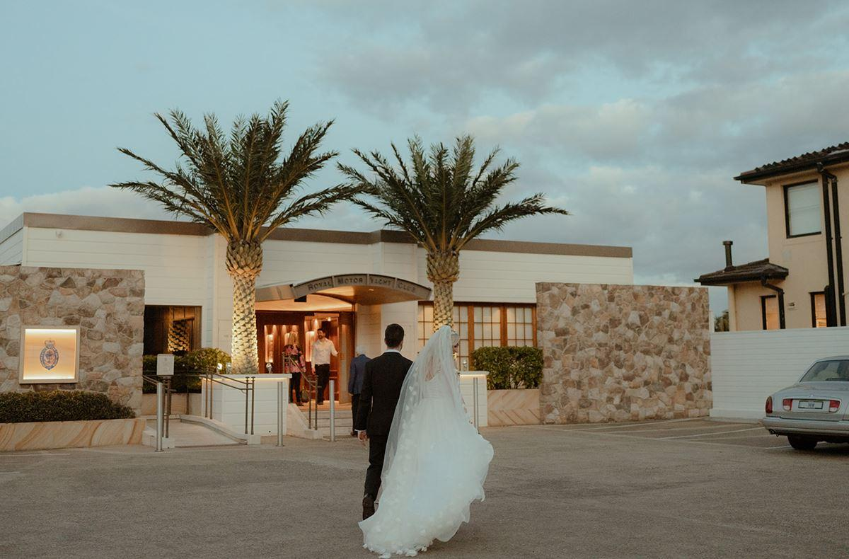 sydney-wedding-venue-entrance-access.jpg  Bride and groom approaching a Sydney wedding venue entrance with parking and guest access visible