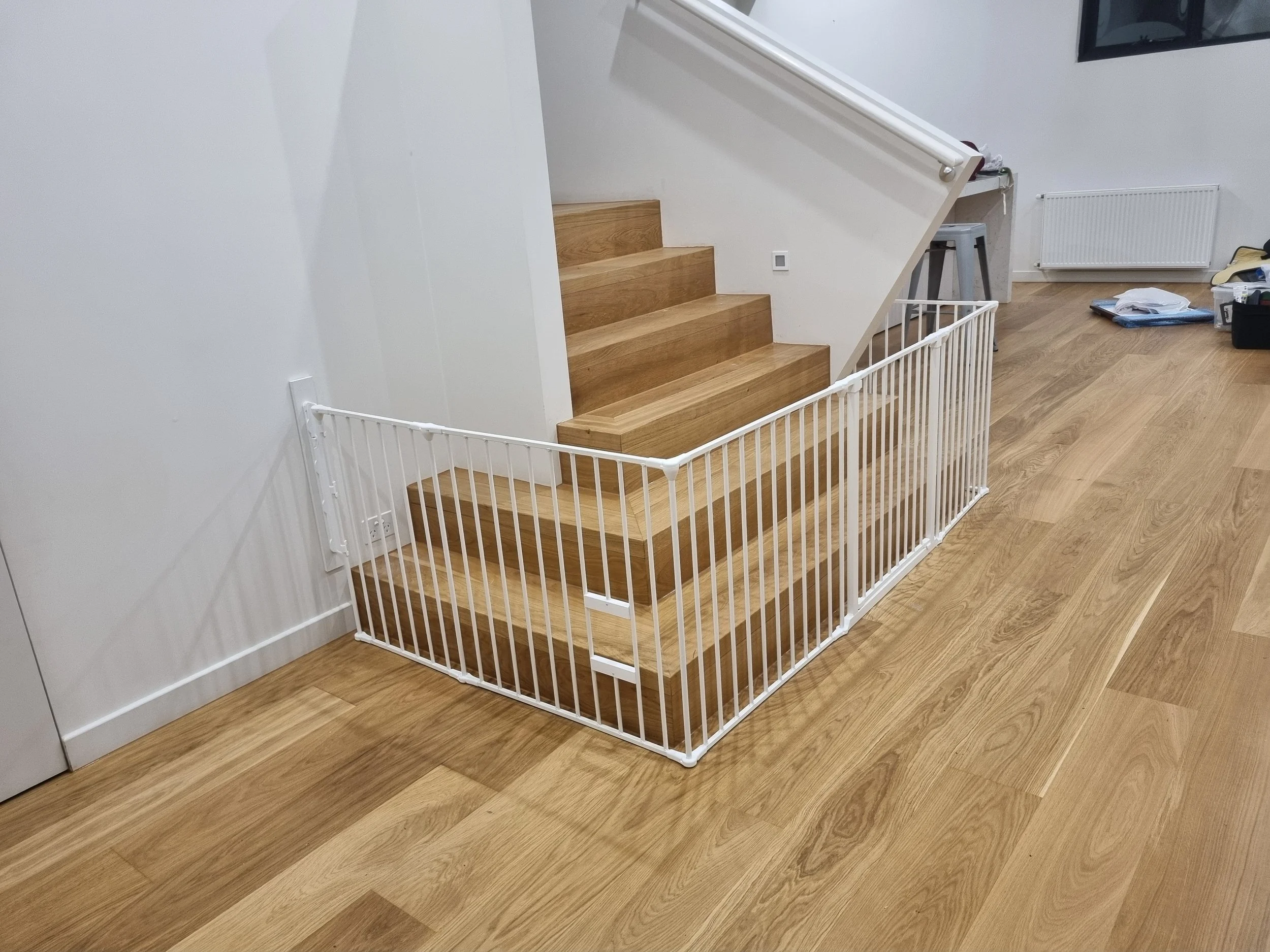 White baby gate along the bottom of timber stairs