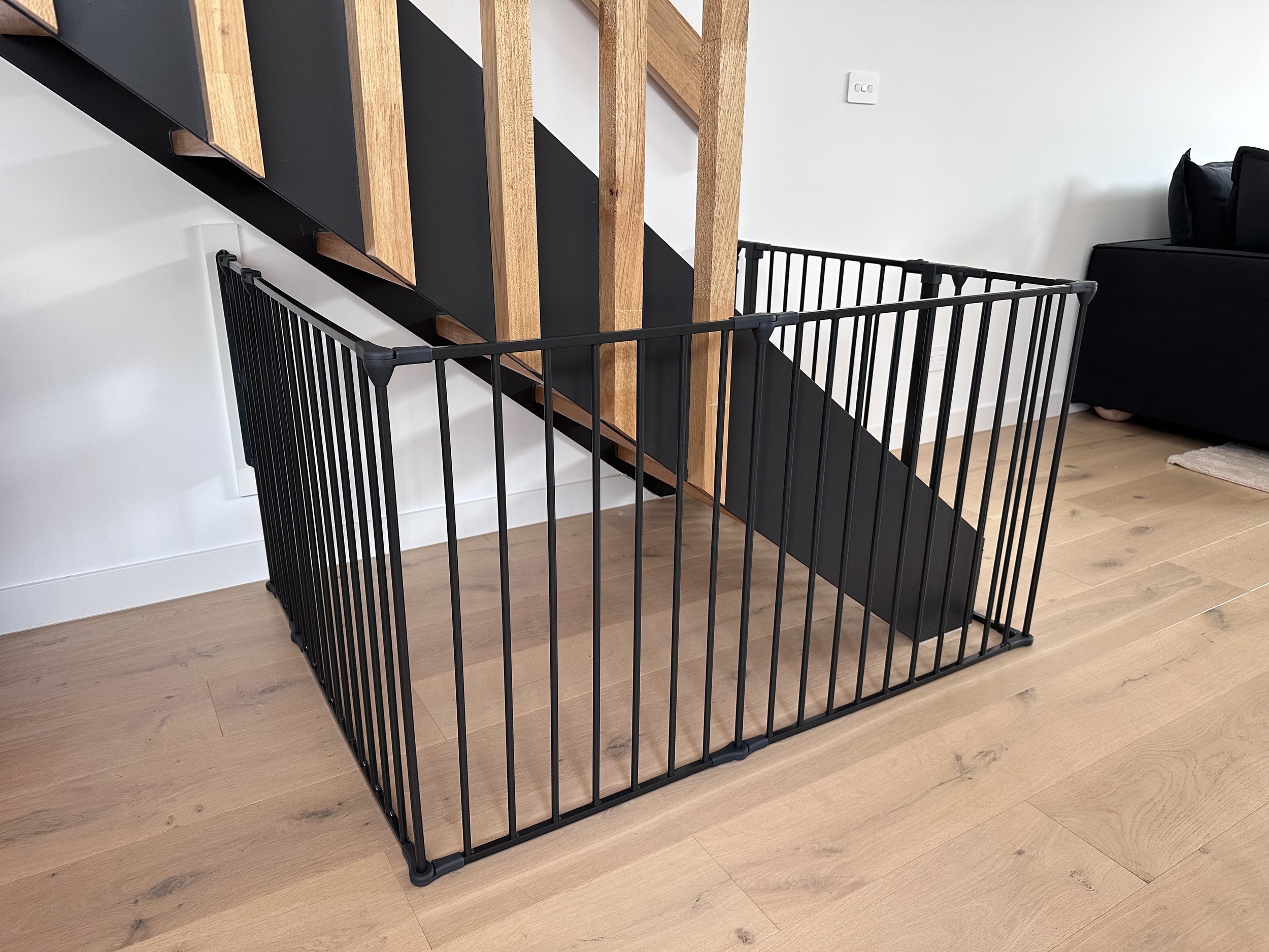 Black gate closing off the space under open stairs