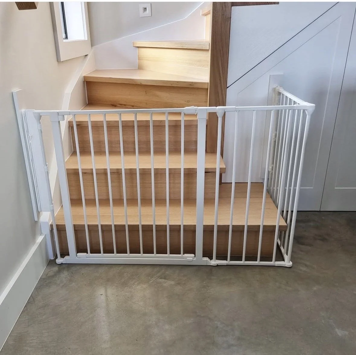 White baby gate across the bottom of timber stairs