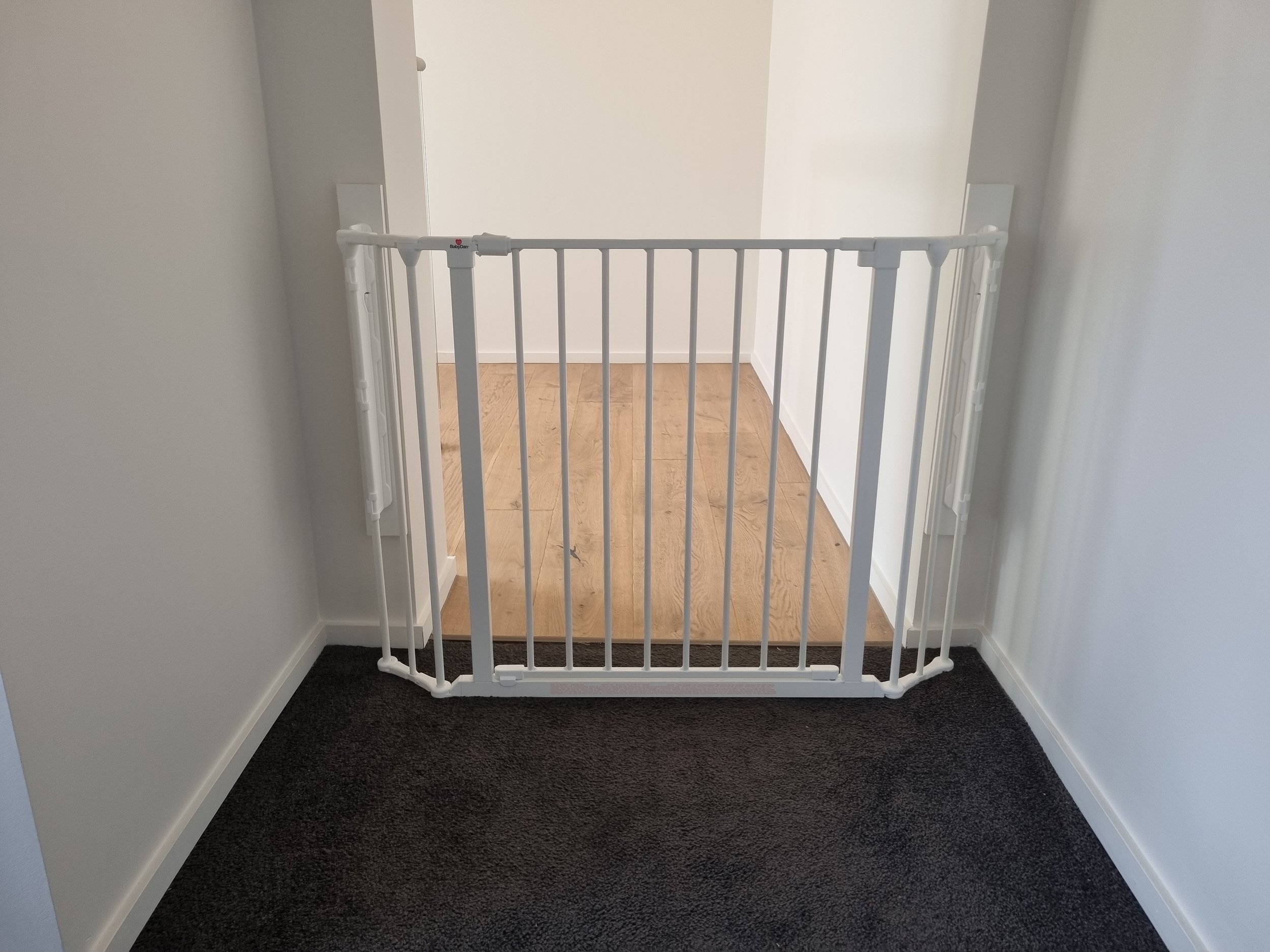 White baby gate across a hallway opening