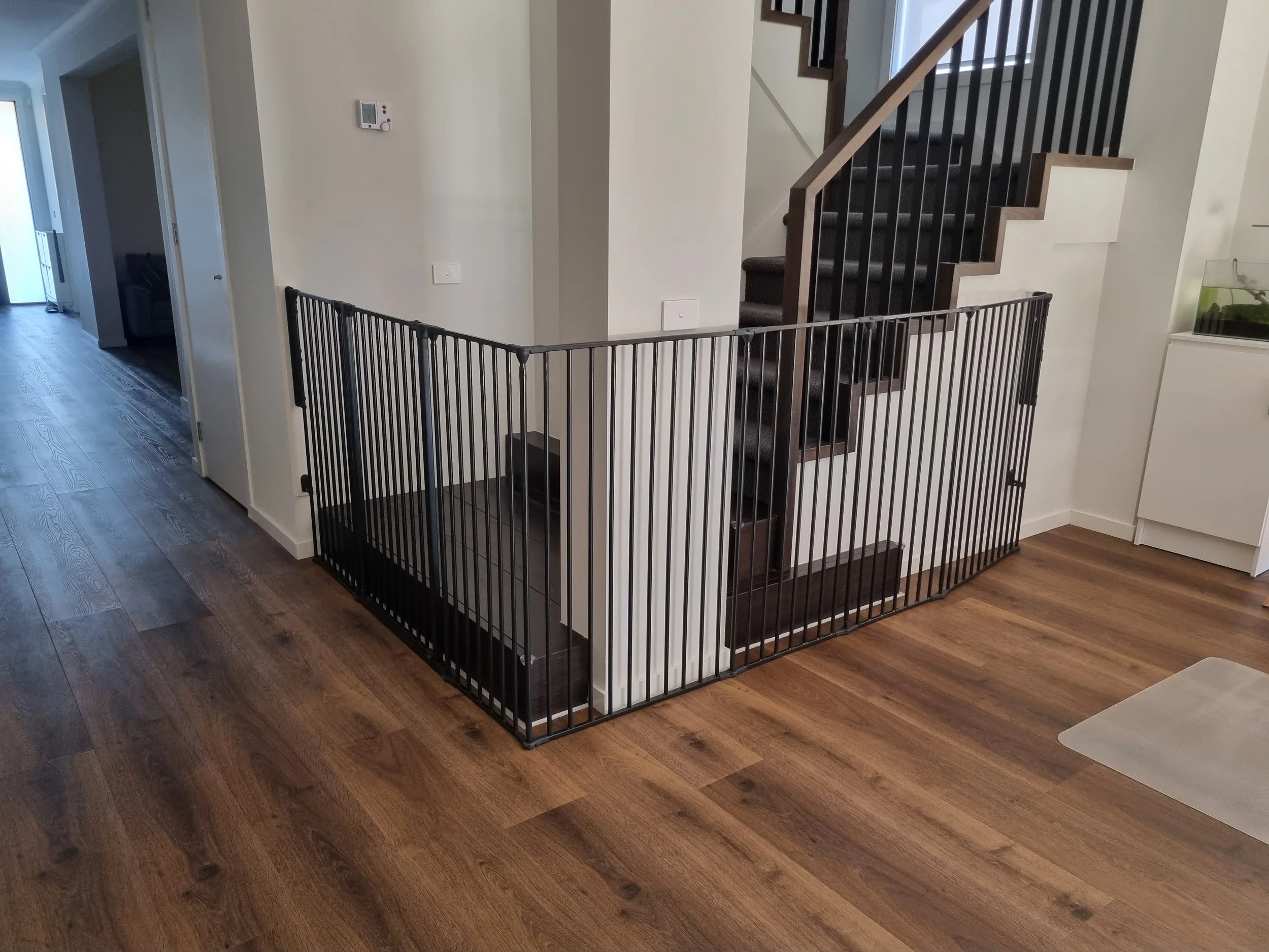 Black gate enclosing the base of an open black staircase