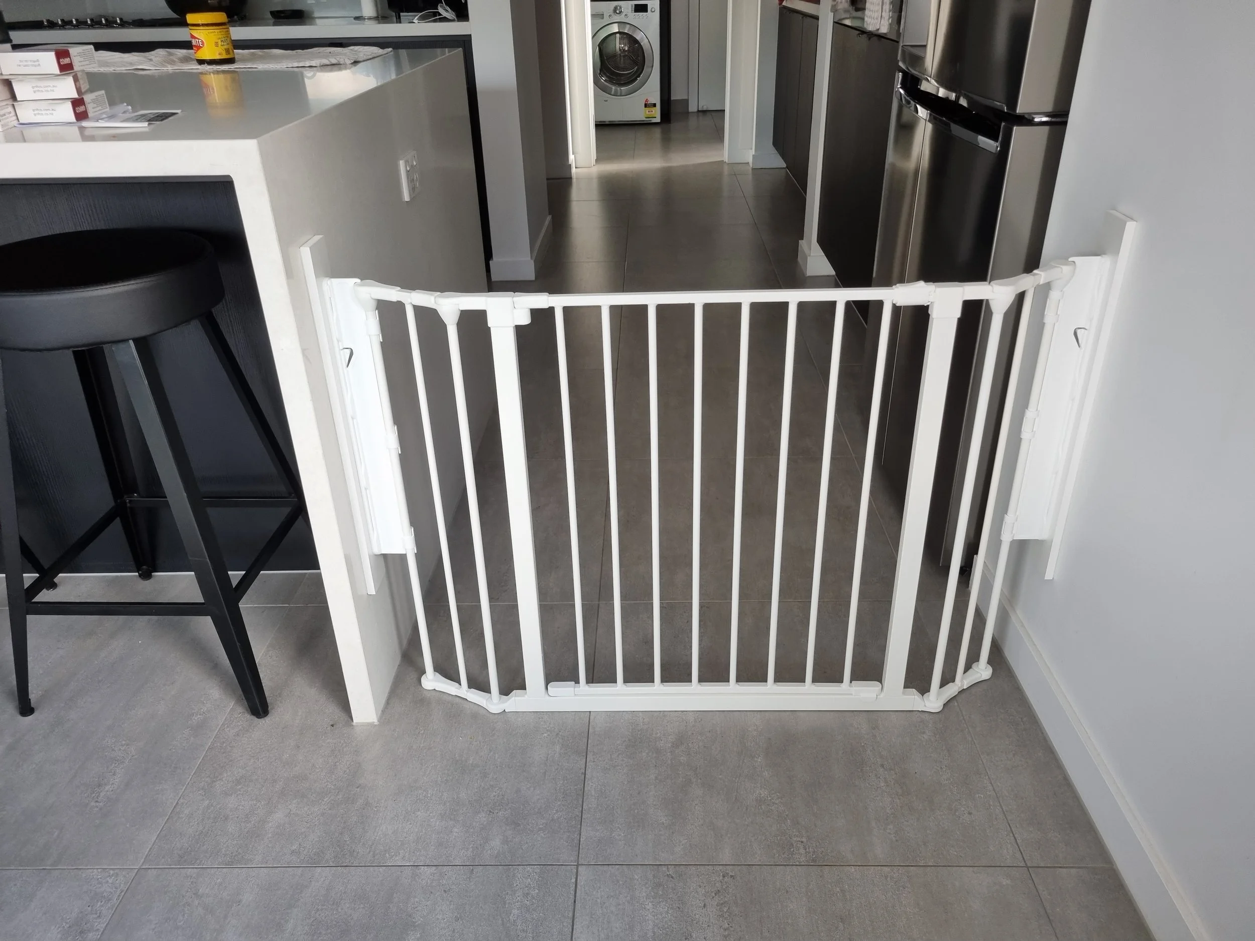 White angled baby gate across a kitchen opening