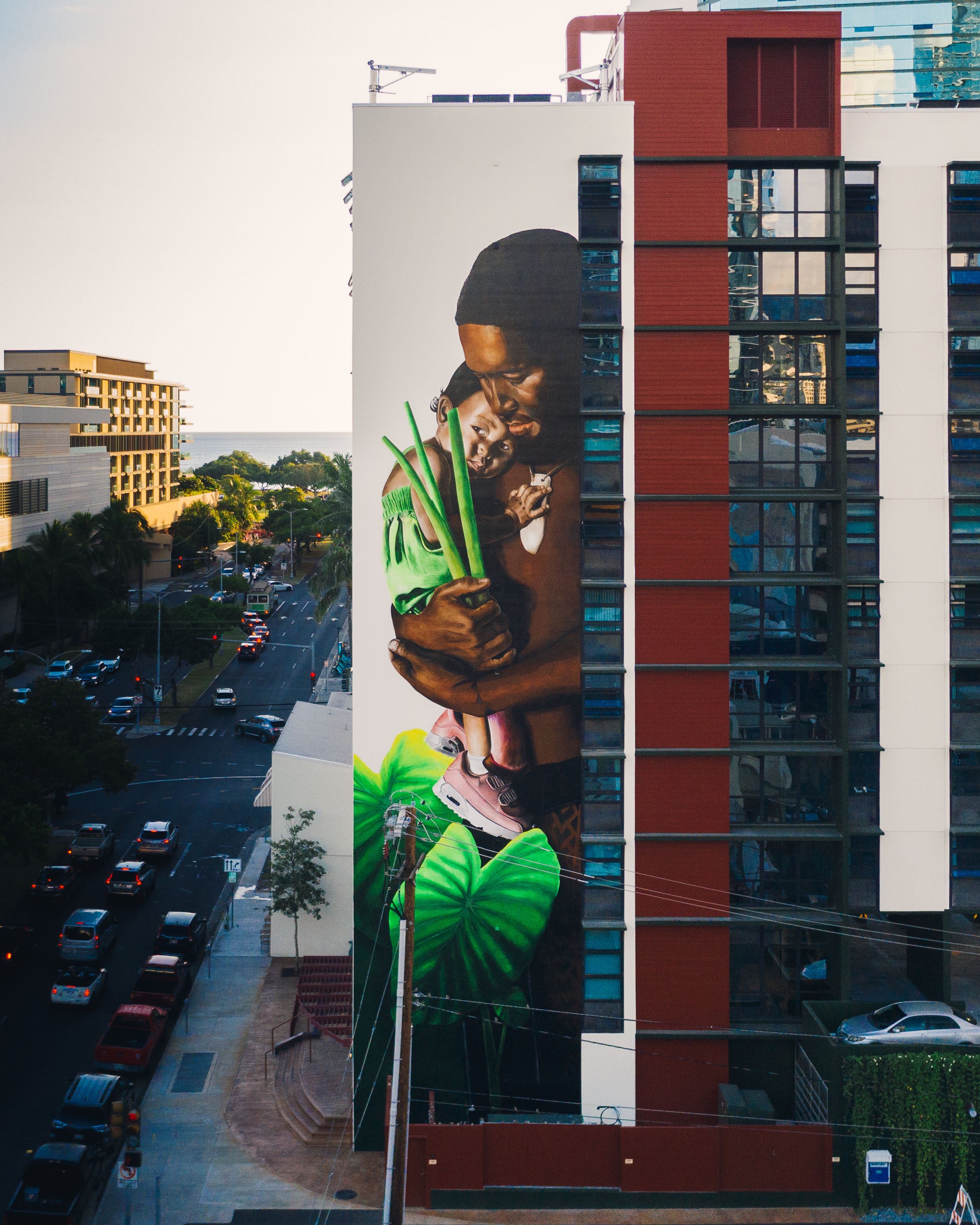  A mural of a father carrying his daughter and taro stems at Hale Kewalo  (photo by Andrew Tran) . 