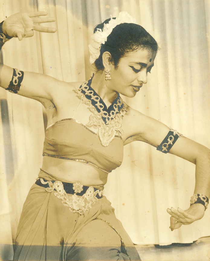  Indru in the midst of performing a dance position from a dance style called Manipur Classical Dance from North India.  