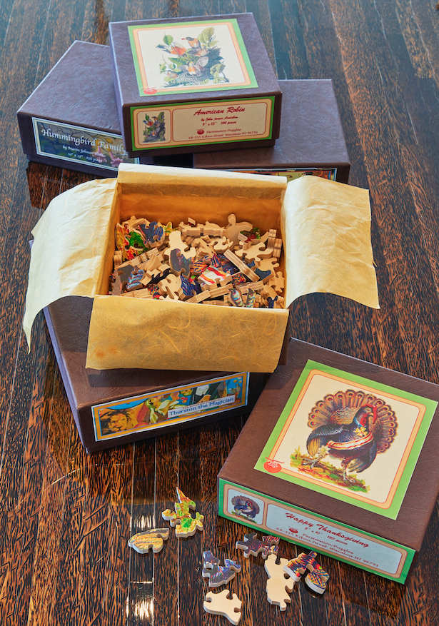  Boxes of Persimmon Puzzles, made by Sharon’s stepdaughter, Ibby Jenkins, are just part of her grand puzzle collection.  Photo by Kyle Rothenborg    