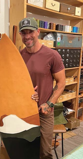  Bluth with one of his custom art pieces — a leather surfboard.   Photo courtesy Michael Bluth  