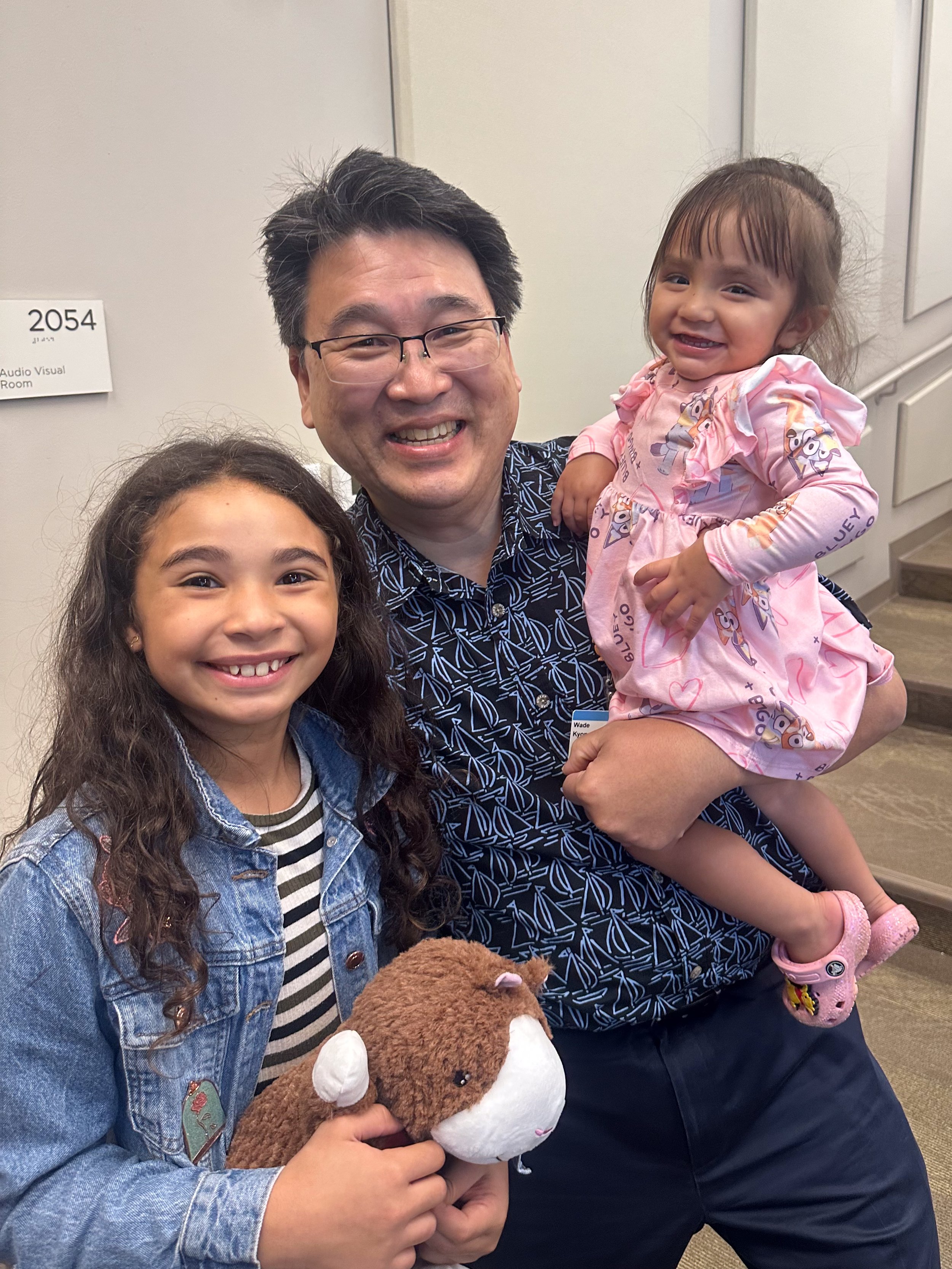  Seeley Borges (right) with her sister, Ainsley, and her pediatric oncologist at Kapi‘olani, Dr. Wade Kyono.   Photo courtesy Hawaii Pacific Health  