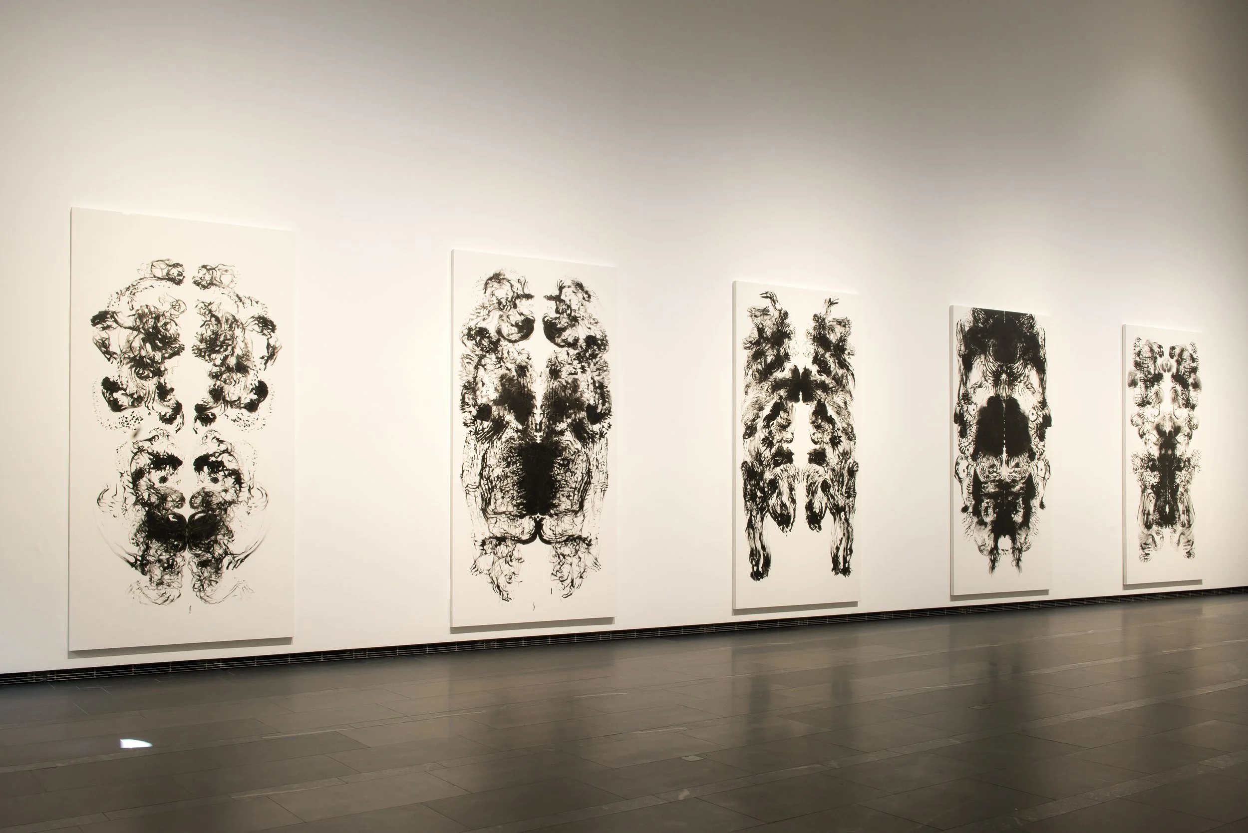 In a gallery, Mark Wallinger’s large id paintings (2015), scaled to his body, line the walls. The mirrored halves evoke the Vitruvian Man and Rorschach inkblots, created by sweeping paint-covered hands across the canvas.