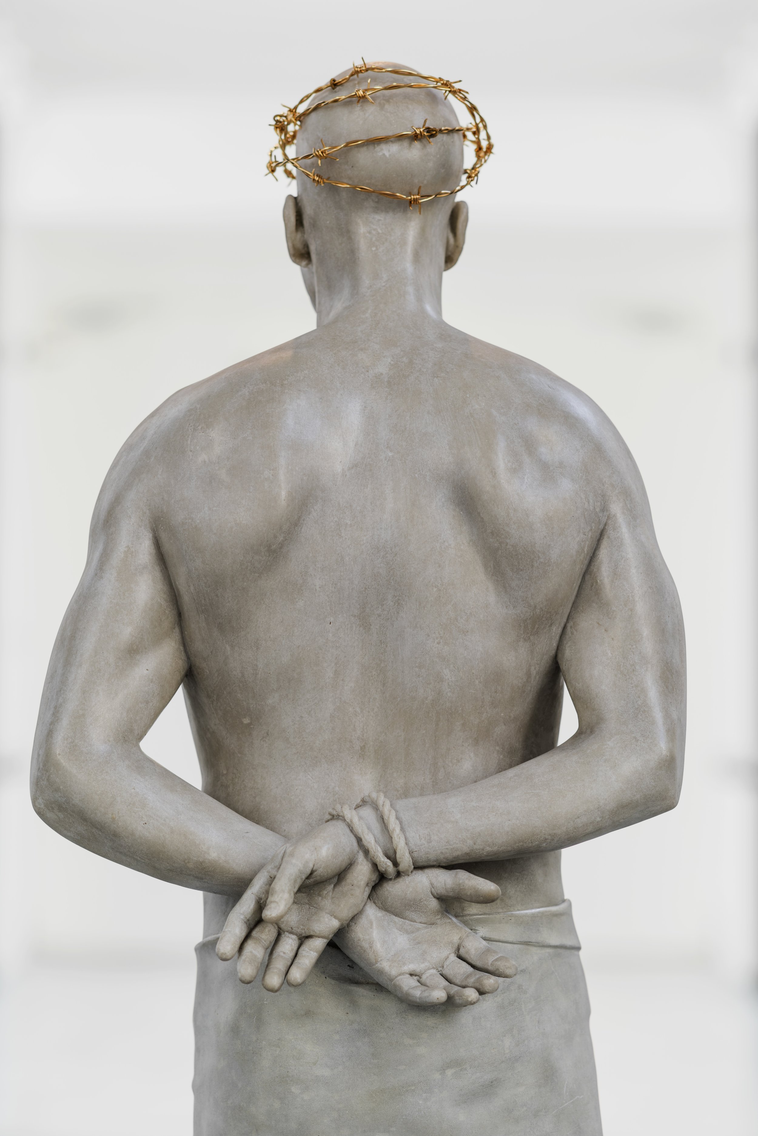 Detail of Mark Wallinger’s Ecce Homo (1999-2000) , a life-sized, white marble resin sculpture of a vulnerable, solitary Christ figure with a barbed wire crown on his head, his hands are behind his back, with a rope tied around his wrists.