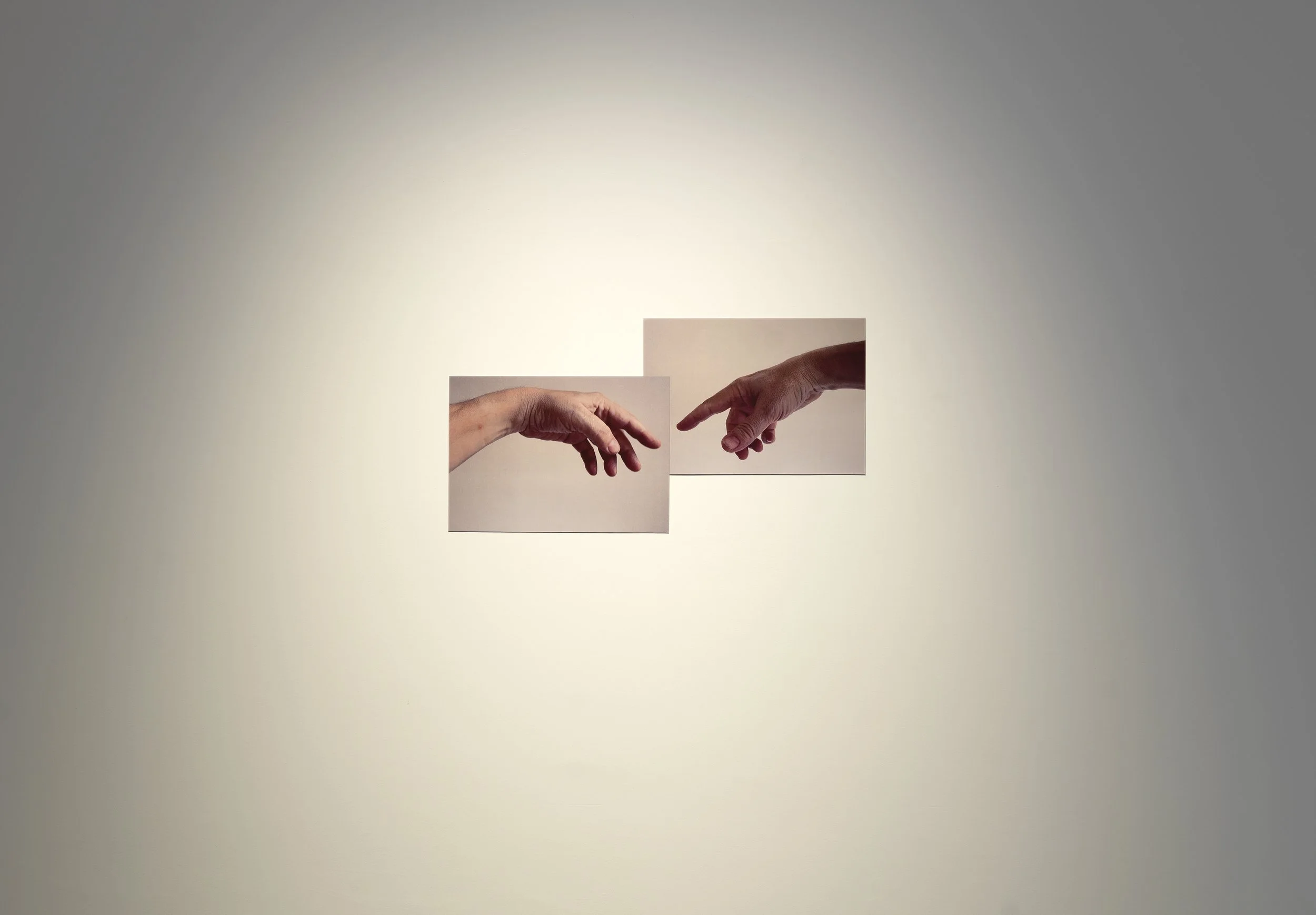 Gallery wall featuring Mark Wallinger’s Ego: two photographs of the artist’s hands reaching toward each other, evoking the iconic Creation of Adam scene.
